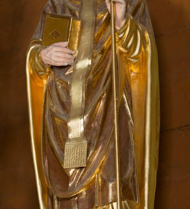 Zdjęcie nr 29: Kamienny ołtarz w jawiszowickim kościele uzyskał kształt prostopadłościanu. Otacza go drewniana obudowa podtrzymująca drewnianą mensę z portatylem. Jego przód zdobi drewniane antepedium ujęte profilowaną ramą z centralnym medalionem z monogramem Marii, otoczonym przez ornament roślinny. Ponad ołtarzem rozpościera się dwukondygnacyjna, architektoniczna nastawa ołtarzowa, flankowana przez dwie bramki. Struktura ołtarza dekorowana jest ciemnozieloną marmoryzacją. Pierwsza kondygnacja retabulum uzyskała trójosiowe założenie wsparte na dwustrefowym cokole, podzielonym płycinami z dekoracją akantową. Artykułują ją dwie pary kolumn o skręconych trzonach i kapitelach kompozytowych. Złocone w całości kolumny podtrzymują belkowanie o wysuniętym gzymsie, wyłamane na ich osi oraz przerwany trójkątny przyczółek. Pole środkowe nastawy wypełnia w całości nisza ujęta profilowaną, złoconą ramą w formie stojącego prostokąta zamkniętego trzema bokami z ośmioboku. W jej wnętrzu znajduje się obraz Matki Boskiej z Dzieciątkiem w typie Matki Boskiej Śnieżnej, zdobiony drewnianą złoconą i srebrzoną sukienką wotywną oraz koronami, a także dwie zasuwy z przedstawieniem św. Marcina, biskupa oraz bł. Salomei. Niszę środkową flankują znajdujące się pomiędzy kolumnami wąskie płyciny zwieńczone konchami. Na ich tle ustawiono figury św. Piotra i św. Pawła. Ponad nimi widoczne są na belkowaniu płaskorzeźbione i złocone girlandy kwiatowe oraz rozety. Na przerwanym przyczółku umieszczono dwie figury siedzących aniołów. Na mensie ołtarza centralnie ustawiono prostopadłościenne tabernakulum w drewnianej obudowie ujęte dwiema kolumienkami kompozytowymi o skręconych trzonach podtrzymujących belkowanie, do którego przymocowano świeczniki na sakramentki. Umieszczony na jego szczycie prosty tron eucharystyczny bez zaplecka flankują dwie figury uskrzydlonych aniołków. Drugą, jednoosiową kondygnację nastawy ujmuje także para złoconych kolumn o skręconych trzonach i kapitelach kompozytowych, ustawionych na cokołach, dźwigających imposty. Pomiędzy kolumnami nad polem z obrazem Wniebowzięcia Matki Boskiej widoczny jest wysunięty fragment gzymsu. Obraz ujęty został złoconą i profilowaną ramą w formie kwadratu o ściętych narożach. Po bokach obrazu na płycinie rozmieszczono złocone dekoracje akantowe. W zwieńczeniu na belkowaniu usytuowano dwa putta flankujące rzeźbę apokaliptycznego baranka leżącego na księdze. Obie kondygnacje ujmują uszaki z akantu suchego. Po bokach nastawy usytuowano dwie bramki flankowane pilastrami. Ich zwężające się ku dołowi trzony podtrzymują nadwieszony łuk półkolisty. Całość zamyka gzyms z centralnie usytuowanym cokołem, na którym stoją figury św. Stanisława i św. Wojciecha. Po ich bokach figur przy ścianach ustawiono rzeźbione i złocone wazony z kwiatami. 