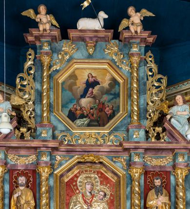 Zdjęcie nr 35: Kamienny ołtarz w jawiszowickim kościele uzyskał kształt prostopadłościanu. Otacza go drewniana obudowa podtrzymująca drewnianą mensę z portatylem. Jego przód zdobi drewniane antepedium ujęte profilowaną ramą z centralnym medalionem z monogramem Marii, otoczonym przez ornament roślinny. Ponad ołtarzem rozpościera się dwukondygnacyjna, architektoniczna nastawa ołtarzowa, flankowana przez dwie bramki. Struktura ołtarza dekorowana jest ciemnozieloną marmoryzacją. Pierwsza kondygnacja retabulum uzyskała trójosiowe założenie wsparte na dwustrefowym cokole, podzielonym płycinami z dekoracją akantową. Artykułują ją dwie pary kolumn o skręconych trzonach i kapitelach kompozytowych. Złocone w całości kolumny podtrzymują belkowanie o wysuniętym gzymsie, wyłamane na ich osi oraz przerwany trójkątny przyczółek. Pole środkowe nastawy wypełnia w całości nisza ujęta profilowaną, złoconą ramą w formie stojącego prostokąta zamkniętego trzema bokami z ośmioboku. W jej wnętrzu znajduje się obraz Matki Boskiej z Dzieciątkiem w typie Matki Boskiej Śnieżnej, zdobiony drewnianą złoconą i srebrzoną sukienką wotywną oraz koronami, a także dwie zasuwy z przedstawieniem św. Marcina, biskupa oraz bł. Salomei. Niszę środkową flankują znajdujące się pomiędzy kolumnami wąskie płyciny zwieńczone konchami. Na ich tle ustawiono figury św. Piotra i św. Pawła. Ponad nimi widoczne są na belkowaniu płaskorzeźbione i złocone girlandy kwiatowe oraz rozety. Na przerwanym przyczółku umieszczono dwie figury siedzących aniołów. Na mensie ołtarza centralnie ustawiono prostopadłościenne tabernakulum w drewnianej obudowie ujęte dwiema kolumienkami kompozytowymi o skręconych trzonach podtrzymujących belkowanie, do którego przymocowano świeczniki na sakramentki. Umieszczony na jego szczycie prosty tron eucharystyczny bez zaplecka flankują dwie figury uskrzydlonych aniołków. Drugą, jednoosiową kondygnację nastawy ujmuje także para złoconych kolumn o skręconych trzonach i kapitelach kompozytowych, ustawionych na cokołach, dźwigających imposty. Pomiędzy kolumnami nad polem z obrazem Wniebowzięcia Matki Boskiej widoczny jest wysunięty fragment gzymsu. Obraz ujęty został złoconą i profilowaną ramą w formie kwadratu o ściętych narożach. Po bokach obrazu na płycinie rozmieszczono złocone dekoracje akantowe. W zwieńczeniu na belkowaniu usytuowano dwa putta flankujące rzeźbę apokaliptycznego baranka leżącego na księdze. Obie kondygnacje ujmują uszaki z akantu suchego. Po bokach nastawy usytuowano dwie bramki flankowane pilastrami. Ich zwężające się ku dołowi trzony podtrzymują nadwieszony łuk półkolisty. Całość zamyka gzyms z centralnie usytuowanym cokołem, na którym stoją figury św. Stanisława i św. Wojciecha. Po ich bokach figur przy ścianach ustawiono rzeźbione i złocone wazony z kwiatami. 