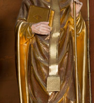 Zdjęcie nr 31: Kamienny ołtarz w jawiszowickim kościele uzyskał kształt prostopadłościanu. Otacza go drewniana obudowa podtrzymująca drewnianą mensę z portatylem. Jego przód zdobi drewniane antepedium ujęte profilowaną ramą z centralnym medalionem z monogramem Marii, otoczonym przez ornament roślinny. Ponad ołtarzem rozpościera się dwukondygnacyjna, architektoniczna nastawa ołtarzowa, flankowana przez dwie bramki. Struktura ołtarza dekorowana jest ciemnozieloną marmoryzacją. Pierwsza kondygnacja retabulum uzyskała trójosiowe założenie wsparte na dwustrefowym cokole, podzielonym płycinami z dekoracją akantową. Artykułują ją dwie pary kolumn o skręconych trzonach i kapitelach kompozytowych. Złocone w całości kolumny podtrzymują belkowanie o wysuniętym gzymsie, wyłamane na ich osi oraz przerwany trójkątny przyczółek. Pole środkowe nastawy wypełnia w całości nisza ujęta profilowaną, złoconą ramą w formie stojącego prostokąta zamkniętego trzema bokami z ośmioboku. W jej wnętrzu znajduje się obraz Matki Boskiej z Dzieciątkiem w typie Matki Boskiej Śnieżnej, zdobiony drewnianą złoconą i srebrzoną sukienką wotywną oraz koronami, a także dwie zasuwy z przedstawieniem św. Marcina, biskupa oraz bł. Salomei. Niszę środkową flankują znajdujące się pomiędzy kolumnami wąskie płyciny zwieńczone konchami. Na ich tle ustawiono figury św. Piotra i św. Pawła. Ponad nimi widoczne są na belkowaniu płaskorzeźbione i złocone girlandy kwiatowe oraz rozety. Na przerwanym przyczółku umieszczono dwie figury siedzących aniołów. Na mensie ołtarza centralnie ustawiono prostopadłościenne tabernakulum w drewnianej obudowie ujęte dwiema kolumienkami kompozytowymi o skręconych trzonach podtrzymujących belkowanie, do którego przymocowano świeczniki na sakramentki. Umieszczony na jego szczycie prosty tron eucharystyczny bez zaplecka flankują dwie figury uskrzydlonych aniołków. Drugą, jednoosiową kondygnację nastawy ujmuje także para złoconych kolumn o skręconych trzonach i kapitelach kompozytowych, ustawionych na cokołach, dźwigających imposty. Pomiędzy kolumnami nad polem z obrazem Wniebowzięcia Matki Boskiej widoczny jest wysunięty fragment gzymsu. Obraz ujęty został złoconą i profilowaną ramą w formie kwadratu o ściętych narożach. Po bokach obrazu na płycinie rozmieszczono złocone dekoracje akantowe. W zwieńczeniu na belkowaniu usytuowano dwa putta flankujące rzeźbę apokaliptycznego baranka leżącego na księdze. Obie kondygnacje ujmują uszaki z akantu suchego. Po bokach nastawy usytuowano dwie bramki flankowane pilastrami. Ich zwężające się ku dołowi trzony podtrzymują nadwieszony łuk półkolisty. Całość zamyka gzyms z centralnie usytuowanym cokołem, na którym stoją figury św. Stanisława i św. Wojciecha. Po ich bokach figur przy ścianach ustawiono rzeźbione i złocone wazony z kwiatami. 