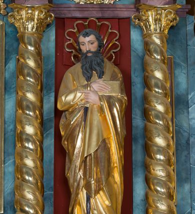 Zdjęcie nr 5: Kamienny ołtarz w jawiszowickim kościele uzyskał kształt prostopadłościanu. Otacza go drewniana obudowa podtrzymująca drewnianą mensę z portatylem. Jego przód zdobi drewniane antepedium ujęte profilowaną ramą z centralnym medalionem z monogramem Marii, otoczonym przez ornament roślinny. Ponad ołtarzem rozpościera się dwukondygnacyjna, architektoniczna nastawa ołtarzowa, flankowana przez dwie bramki. Struktura ołtarza dekorowana jest ciemnozieloną marmoryzacją. Pierwsza kondygnacja retabulum uzyskała trójosiowe założenie wsparte na dwustrefowym cokole, podzielonym płycinami z dekoracją akantową. Artykułują ją dwie pary kolumn o skręconych trzonach i kapitelach kompozytowych. Złocone w całości kolumny podtrzymują belkowanie o wysuniętym gzymsie, wyłamane na ich osi oraz przerwany trójkątny przyczółek. Pole środkowe nastawy wypełnia w całości nisza ujęta profilowaną, złoconą ramą w formie stojącego prostokąta zamkniętego trzema bokami z ośmioboku. W jej wnętrzu znajduje się obraz Matki Boskiej z Dzieciątkiem w typie Matki Boskiej Śnieżnej, zdobiony drewnianą złoconą i srebrzoną sukienką wotywną oraz koronami, a także dwie zasuwy z przedstawieniem św. Marcina, biskupa oraz bł. Salomei. Niszę środkową flankują znajdujące się pomiędzy kolumnami wąskie płyciny zwieńczone konchami. Na ich tle ustawiono figury św. Piotra i św. Pawła. Ponad nimi widoczne są na belkowaniu płaskorzeźbione i złocone girlandy kwiatowe oraz rozety. Na przerwanym przyczółku umieszczono dwie figury siedzących aniołów. Na mensie ołtarza centralnie ustawiono prostopadłościenne tabernakulum w drewnianej obudowie ujęte dwiema kolumienkami kompozytowymi o skręconych trzonach podtrzymujących belkowanie, do którego przymocowano świeczniki na sakramentki. Umieszczony na jego szczycie prosty tron eucharystyczny bez zaplecka flankują dwie figury uskrzydlonych aniołków. Drugą, jednoosiową kondygnację nastawy ujmuje także para złoconych kolumn o skręconych trzonach i kapitelach kompozytowych, ustawionych na cokołach, dźwigających imposty. Pomiędzy kolumnami nad polem z obrazem Wniebowzięcia Matki Boskiej widoczny jest wysunięty fragment gzymsu. Obraz ujęty został złoconą i profilowaną ramą w formie kwadratu o ściętych narożach. Po bokach obrazu na płycinie rozmieszczono złocone dekoracje akantowe. W zwieńczeniu na belkowaniu usytuowano dwa putta flankujące rzeźbę apokaliptycznego baranka leżącego na księdze. Obie kondygnacje ujmują uszaki z akantu suchego. Po bokach nastawy usytuowano dwie bramki flankowane pilastrami. Ich zwężające się ku dołowi trzony podtrzymują nadwieszony łuk półkolisty. Całość zamyka gzyms z centralnie usytuowanym cokołem, na którym stoją figury św. Stanisława i św. Wojciecha. Po ich bokach figur przy ścianach ustawiono rzeźbione i złocone wazony z kwiatami. 