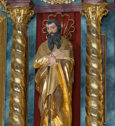 Zdjęcie nr 4: Kamienny ołtarz w jawiszowickim kościele uzyskał kształt prostopadłościanu. Otacza go drewniana obudowa podtrzymująca drewnianą mensę z portatylem. Jego przód zdobi drewniane antepedium ujęte profilowaną ramą z centralnym medalionem z monogramem Marii, otoczonym przez ornament roślinny. Ponad ołtarzem rozpościera się dwukondygnacyjna, architektoniczna nastawa ołtarzowa, flankowana przez dwie bramki. Struktura ołtarza dekorowana jest ciemnozieloną marmoryzacją. Pierwsza kondygnacja retabulum uzyskała trójosiowe założenie wsparte na dwustrefowym cokole, podzielonym płycinami z dekoracją akantową. Artykułują ją dwie pary kolumn o skręconych trzonach i kapitelach kompozytowych. Złocone w całości kolumny podtrzymują belkowanie o wysuniętym gzymsie, wyłamane na ich osi oraz przerwany trójkątny przyczółek. Pole środkowe nastawy wypełnia w całości nisza ujęta profilowaną, złoconą ramą w formie stojącego prostokąta zamkniętego trzema bokami z ośmioboku. W jej wnętrzu znajduje się obraz Matki Boskiej z Dzieciątkiem w typie Matki Boskiej Śnieżnej, zdobiony drewnianą złoconą i srebrzoną sukienką wotywną oraz koronami, a także dwie zasuwy z przedstawieniem św. Marcina, biskupa oraz bł. Salomei. Niszę środkową flankują znajdujące się pomiędzy kolumnami wąskie płyciny zwieńczone konchami. Na ich tle ustawiono figury św. Piotra i św. Pawła. Ponad nimi widoczne są na belkowaniu płaskorzeźbione i złocone girlandy kwiatowe oraz rozety. Na przerwanym przyczółku umieszczono dwie figury siedzących aniołów. Na mensie ołtarza centralnie ustawiono prostopadłościenne tabernakulum w drewnianej obudowie ujęte dwiema kolumienkami kompozytowymi o skręconych trzonach podtrzymujących belkowanie, do którego przymocowano świeczniki na sakramentki. Umieszczony na jego szczycie prosty tron eucharystyczny bez zaplecka flankują dwie figury uskrzydlonych aniołków. Drugą, jednoosiową kondygnację nastawy ujmuje także para złoconych kolumn o skręconych trzonach i kapitelach kompozytowych, ustawionych na cokołach, dźwigających imposty. Pomiędzy kolumnami nad polem z obrazem Wniebowzięcia Matki Boskiej widoczny jest wysunięty fragment gzymsu. Obraz ujęty został złoconą i profilowaną ramą w formie kwadratu o ściętych narożach. Po bokach obrazu na płycinie rozmieszczono złocone dekoracje akantowe. W zwieńczeniu na belkowaniu usytuowano dwa putta flankujące rzeźbę apokaliptycznego baranka leżącego na księdze. Obie kondygnacje ujmują uszaki z akantu suchego. Po bokach nastawy usytuowano dwie bramki flankowane pilastrami. Ich zwężające się ku dołowi trzony podtrzymują nadwieszony łuk półkolisty. Całość zamyka gzyms z centralnie usytuowanym cokołem, na którym stoją figury św. Stanisława i św. Wojciecha. Po ich bokach figur przy ścianach ustawiono rzeźbione i złocone wazony z kwiatami. 