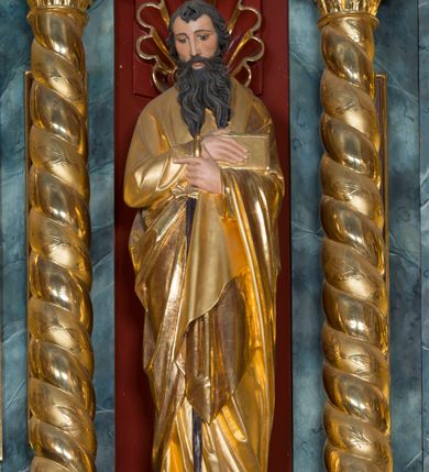 Zdjęcie nr 7: Kamienny ołtarz w jawiszowickim kościele uzyskał kształt prostopadłościanu. Otacza go drewniana obudowa podtrzymująca drewnianą mensę z portatylem. Jego przód zdobi drewniane antepedium ujęte profilowaną ramą z centralnym medalionem z monogramem Marii, otoczonym przez ornament roślinny. Ponad ołtarzem rozpościera się dwukondygnacyjna, architektoniczna nastawa ołtarzowa, flankowana przez dwie bramki. Struktura ołtarza dekorowana jest ciemnozieloną marmoryzacją. Pierwsza kondygnacja retabulum uzyskała trójosiowe założenie wsparte na dwustrefowym cokole, podzielonym płycinami z dekoracją akantową. Artykułują ją dwie pary kolumn o skręconych trzonach i kapitelach kompozytowych. Złocone w całości kolumny podtrzymują belkowanie o wysuniętym gzymsie, wyłamane na ich osi oraz przerwany trójkątny przyczółek. Pole środkowe nastawy wypełnia w całości nisza ujęta profilowaną, złoconą ramą w formie stojącego prostokąta zamkniętego trzema bokami z ośmioboku. W jej wnętrzu znajduje się obraz Matki Boskiej z Dzieciątkiem w typie Matki Boskiej Śnieżnej, zdobiony drewnianą złoconą i srebrzoną sukienką wotywną oraz koronami, a także dwie zasuwy z przedstawieniem św. Marcina, biskupa oraz bł. Salomei. Niszę środkową flankują znajdujące się pomiędzy kolumnami wąskie płyciny zwieńczone konchami. Na ich tle ustawiono figury św. Piotra i św. Pawła. Ponad nimi widoczne są na belkowaniu płaskorzeźbione i złocone girlandy kwiatowe oraz rozety. Na przerwanym przyczółku umieszczono dwie figury siedzących aniołów. Na mensie ołtarza centralnie ustawiono prostopadłościenne tabernakulum w drewnianej obudowie ujęte dwiema kolumienkami kompozytowymi o skręconych trzonach podtrzymujących belkowanie, do którego przymocowano świeczniki na sakramentki. Umieszczony na jego szczycie prosty tron eucharystyczny bez zaplecka flankują dwie figury uskrzydlonych aniołków. Drugą, jednoosiową kondygnację nastawy ujmuje także para złoconych kolumn o skręconych trzonach i kapitelach kompozytowych, ustawionych na cokołach, dźwigających imposty. Pomiędzy kolumnami nad polem z obrazem Wniebowzięcia Matki Boskiej widoczny jest wysunięty fragment gzymsu. Obraz ujęty został złoconą i profilowaną ramą w formie kwadratu o ściętych narożach. Po bokach obrazu na płycinie rozmieszczono złocone dekoracje akantowe. W zwieńczeniu na belkowaniu usytuowano dwa putta flankujące rzeźbę apokaliptycznego baranka leżącego na księdze. Obie kondygnacje ujmują uszaki z akantu suchego. Po bokach nastawy usytuowano dwie bramki flankowane pilastrami. Ich zwężające się ku dołowi trzony podtrzymują nadwieszony łuk półkolisty. Całość zamyka gzyms z centralnie usytuowanym cokołem, na którym stoją figury św. Stanisława i św. Wojciecha. Po ich bokach figur przy ścianach ustawiono rzeźbione i złocone wazony z kwiatami. 