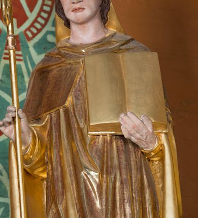 Zdjęcie nr 24: Kamienny ołtarz w jawiszowickim kościele uzyskał kształt prostopadłościanu. Otacza go drewniana obudowa podtrzymująca drewnianą mensę z portatylem. Jego przód zdobi drewniane antepedium ujęte profilowaną ramą z centralnym medalionem z monogramem Marii, otoczonym przez ornament roślinny. Ponad ołtarzem rozpościera się dwukondygnacyjna, architektoniczna nastawa ołtarzowa, flankowana przez dwie bramki. Struktura ołtarza dekorowana jest ciemnozieloną marmoryzacją. Pierwsza kondygnacja retabulum uzyskała trójosiowe założenie wsparte na dwustrefowym cokole, podzielonym płycinami z dekoracją akantową. Artykułują ją dwie pary kolumn o skręconych trzonach i kapitelach kompozytowych. Złocone w całości kolumny podtrzymują belkowanie o wysuniętym gzymsie, wyłamane na ich osi oraz przerwany trójkątny przyczółek. Pole środkowe nastawy wypełnia w całości nisza ujęta profilowaną, złoconą ramą w formie stojącego prostokąta zamkniętego trzema bokami z ośmioboku. W jej wnętrzu znajduje się obraz Matki Boskiej z Dzieciątkiem w typie Matki Boskiej Śnieżnej, zdobiony drewnianą złoconą i srebrzoną sukienką wotywną oraz koronami, a także dwie zasuwy z przedstawieniem św. Marcina, biskupa oraz bł. Salomei. Niszę środkową flankują znajdujące się pomiędzy kolumnami wąskie płyciny zwieńczone konchami. Na ich tle ustawiono figury św. Piotra i św. Pawła. Ponad nimi widoczne są na belkowaniu płaskorzeźbione i złocone girlandy kwiatowe oraz rozety. Na przerwanym przyczółku umieszczono dwie figury siedzących aniołów. Na mensie ołtarza centralnie ustawiono prostopadłościenne tabernakulum w drewnianej obudowie ujęte dwiema kolumienkami kompozytowymi o skręconych trzonach podtrzymujących belkowanie, do którego przymocowano świeczniki na sakramentki. Umieszczony na jego szczycie prosty tron eucharystyczny bez zaplecka flankują dwie figury uskrzydlonych aniołków. Drugą, jednoosiową kondygnację nastawy ujmuje także para złoconych kolumn o skręconych trzonach i kapitelach kompozytowych, ustawionych na cokołach, dźwigających imposty. Pomiędzy kolumnami nad polem z obrazem Wniebowzięcia Matki Boskiej widoczny jest wysunięty fragment gzymsu. Obraz ujęty został złoconą i profilowaną ramą w formie kwadratu o ściętych narożach. Po bokach obrazu na płycinie rozmieszczono złocone dekoracje akantowe. W zwieńczeniu na belkowaniu usytuowano dwa putta flankujące rzeźbę apokaliptycznego baranka leżącego na księdze. Obie kondygnacje ujmują uszaki z akantu suchego. Po bokach nastawy usytuowano dwie bramki flankowane pilastrami. Ich zwężające się ku dołowi trzony podtrzymują nadwieszony łuk półkolisty. Całość zamyka gzyms z centralnie usytuowanym cokołem, na którym stoją figury św. Stanisława i św. Wojciecha. Po ich bokach figur przy ścianach ustawiono rzeźbione i złocone wazony z kwiatami. 