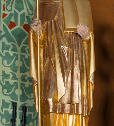 Zdjęcie nr 21: Kamienny ołtarz w jawiszowickim kościele uzyskał kształt prostopadłościanu. Otacza go drewniana obudowa podtrzymująca drewnianą mensę z portatylem. Jego przód zdobi drewniane antepedium ujęte profilowaną ramą z centralnym medalionem z monogramem Marii, otoczonym przez ornament roślinny. Ponad ołtarzem rozpościera się dwukondygnacyjna, architektoniczna nastawa ołtarzowa, flankowana przez dwie bramki. Struktura ołtarza dekorowana jest ciemnozieloną marmoryzacją. Pierwsza kondygnacja retabulum uzyskała trójosiowe założenie wsparte na dwustrefowym cokole, podzielonym płycinami z dekoracją akantową. Artykułują ją dwie pary kolumn o skręconych trzonach i kapitelach kompozytowych. Złocone w całości kolumny podtrzymują belkowanie o wysuniętym gzymsie, wyłamane na ich osi oraz przerwany trójkątny przyczółek. Pole środkowe nastawy wypełnia w całości nisza ujęta profilowaną, złoconą ramą w formie stojącego prostokąta zamkniętego trzema bokami z ośmioboku. W jej wnętrzu znajduje się obraz Matki Boskiej z Dzieciątkiem w typie Matki Boskiej Śnieżnej, zdobiony drewnianą złoconą i srebrzoną sukienką wotywną oraz koronami, a także dwie zasuwy z przedstawieniem św. Marcina, biskupa oraz bł. Salomei. Niszę środkową flankują znajdujące się pomiędzy kolumnami wąskie płyciny zwieńczone konchami. Na ich tle ustawiono figury św. Piotra i św. Pawła. Ponad nimi widoczne są na belkowaniu płaskorzeźbione i złocone girlandy kwiatowe oraz rozety. Na przerwanym przyczółku umieszczono dwie figury siedzących aniołów. Na mensie ołtarza centralnie ustawiono prostopadłościenne tabernakulum w drewnianej obudowie ujęte dwiema kolumienkami kompozytowymi o skręconych trzonach podtrzymujących belkowanie, do którego przymocowano świeczniki na sakramentki. Umieszczony na jego szczycie prosty tron eucharystyczny bez zaplecka flankują dwie figury uskrzydlonych aniołków. Drugą, jednoosiową kondygnację nastawy ujmuje także para złoconych kolumn o skręconych trzonach i kapitelach kompozytowych, ustawionych na cokołach, dźwigających imposty. Pomiędzy kolumnami nad polem z obrazem Wniebowzięcia Matki Boskiej widoczny jest wysunięty fragment gzymsu. Obraz ujęty został złoconą i profilowaną ramą w formie kwadratu o ściętych narożach. Po bokach obrazu na płycinie rozmieszczono złocone dekoracje akantowe. W zwieńczeniu na belkowaniu usytuowano dwa putta flankujące rzeźbę apokaliptycznego baranka leżącego na księdze. Obie kondygnacje ujmują uszaki z akantu suchego. Po bokach nastawy usytuowano dwie bramki flankowane pilastrami. Ich zwężające się ku dołowi trzony podtrzymują nadwieszony łuk półkolisty. Całość zamyka gzyms z centralnie usytuowanym cokołem, na którym stoją figury św. Stanisława i św. Wojciecha. Po ich bokach figur przy ścianach ustawiono rzeźbione i złocone wazony z kwiatami. 