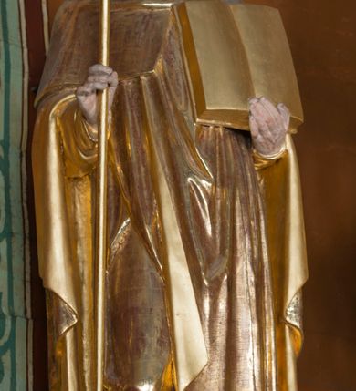 Zdjęcie nr 23: Kamienny ołtarz w jawiszowickim kościele uzyskał kształt prostopadłościanu. Otacza go drewniana obudowa podtrzymująca drewnianą mensę z portatylem. Jego przód zdobi drewniane antepedium ujęte profilowaną ramą z centralnym medalionem z monogramem Marii, otoczonym przez ornament roślinny. Ponad ołtarzem rozpościera się dwukondygnacyjna, architektoniczna nastawa ołtarzowa, flankowana przez dwie bramki. Struktura ołtarza dekorowana jest ciemnozieloną marmoryzacją. Pierwsza kondygnacja retabulum uzyskała trójosiowe założenie wsparte na dwustrefowym cokole, podzielonym płycinami z dekoracją akantową. Artykułują ją dwie pary kolumn o skręconych trzonach i kapitelach kompozytowych. Złocone w całości kolumny podtrzymują belkowanie o wysuniętym gzymsie, wyłamane na ich osi oraz przerwany trójkątny przyczółek. Pole środkowe nastawy wypełnia w całości nisza ujęta profilowaną, złoconą ramą w formie stojącego prostokąta zamkniętego trzema bokami z ośmioboku. W jej wnętrzu znajduje się obraz Matki Boskiej z Dzieciątkiem w typie Matki Boskiej Śnieżnej, zdobiony drewnianą złoconą i srebrzoną sukienką wotywną oraz koronami, a także dwie zasuwy z przedstawieniem św. Marcina, biskupa oraz bł. Salomei. Niszę środkową flankują znajdujące się pomiędzy kolumnami wąskie płyciny zwieńczone konchami. Na ich tle ustawiono figury św. Piotra i św. Pawła. Ponad nimi widoczne są na belkowaniu płaskorzeźbione i złocone girlandy kwiatowe oraz rozety. Na przerwanym przyczółku umieszczono dwie figury siedzących aniołów. Na mensie ołtarza centralnie ustawiono prostopadłościenne tabernakulum w drewnianej obudowie ujęte dwiema kolumienkami kompozytowymi o skręconych trzonach podtrzymujących belkowanie, do którego przymocowano świeczniki na sakramentki. Umieszczony na jego szczycie prosty tron eucharystyczny bez zaplecka flankują dwie figury uskrzydlonych aniołków. Drugą, jednoosiową kondygnację nastawy ujmuje także para złoconych kolumn o skręconych trzonach i kapitelach kompozytowych, ustawionych na cokołach, dźwigających imposty. Pomiędzy kolumnami nad polem z obrazem Wniebowzięcia Matki Boskiej widoczny jest wysunięty fragment gzymsu. Obraz ujęty został złoconą i profilowaną ramą w formie kwadratu o ściętych narożach. Po bokach obrazu na płycinie rozmieszczono złocone dekoracje akantowe. W zwieńczeniu na belkowaniu usytuowano dwa putta flankujące rzeźbę apokaliptycznego baranka leżącego na księdze. Obie kondygnacje ujmują uszaki z akantu suchego. Po bokach nastawy usytuowano dwie bramki flankowane pilastrami. Ich zwężające się ku dołowi trzony podtrzymują nadwieszony łuk półkolisty. Całość zamyka gzyms z centralnie usytuowanym cokołem, na którym stoją figury św. Stanisława i św. Wojciecha. Po ich bokach figur przy ścianach ustawiono rzeźbione i złocone wazony z kwiatami. 