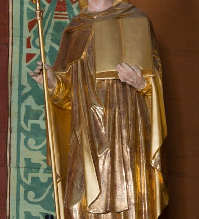 Zdjęcie nr 22: Kamienny ołtarz w jawiszowickim kościele uzyskał kształt prostopadłościanu. Otacza go drewniana obudowa podtrzymująca drewnianą mensę z portatylem. Jego przód zdobi drewniane antepedium ujęte profilowaną ramą z centralnym medalionem z monogramem Marii, otoczonym przez ornament roślinny. Ponad ołtarzem rozpościera się dwukondygnacyjna, architektoniczna nastawa ołtarzowa, flankowana przez dwie bramki. Struktura ołtarza dekorowana jest ciemnozieloną marmoryzacją. Pierwsza kondygnacja retabulum uzyskała trójosiowe założenie wsparte na dwustrefowym cokole, podzielonym płycinami z dekoracją akantową. Artykułują ją dwie pary kolumn o skręconych trzonach i kapitelach kompozytowych. Złocone w całości kolumny podtrzymują belkowanie o wysuniętym gzymsie, wyłamane na ich osi oraz przerwany trójkątny przyczółek. Pole środkowe nastawy wypełnia w całości nisza ujęta profilowaną, złoconą ramą w formie stojącego prostokąta zamkniętego trzema bokami z ośmioboku. W jej wnętrzu znajduje się obraz Matki Boskiej z Dzieciątkiem w typie Matki Boskiej Śnieżnej, zdobiony drewnianą złoconą i srebrzoną sukienką wotywną oraz koronami, a także dwie zasuwy z przedstawieniem św. Marcina, biskupa oraz bł. Salomei. Niszę środkową flankują znajdujące się pomiędzy kolumnami wąskie płyciny zwieńczone konchami. Na ich tle ustawiono figury św. Piotra i św. Pawła. Ponad nimi widoczne są na belkowaniu płaskorzeźbione i złocone girlandy kwiatowe oraz rozety. Na przerwanym przyczółku umieszczono dwie figury siedzących aniołów. Na mensie ołtarza centralnie ustawiono prostopadłościenne tabernakulum w drewnianej obudowie ujęte dwiema kolumienkami kompozytowymi o skręconych trzonach podtrzymujących belkowanie, do którego przymocowano świeczniki na sakramentki. Umieszczony na jego szczycie prosty tron eucharystyczny bez zaplecka flankują dwie figury uskrzydlonych aniołków. Drugą, jednoosiową kondygnację nastawy ujmuje także para złoconych kolumn o skręconych trzonach i kapitelach kompozytowych, ustawionych na cokołach, dźwigających imposty. Pomiędzy kolumnami nad polem z obrazem Wniebowzięcia Matki Boskiej widoczny jest wysunięty fragment gzymsu. Obraz ujęty został złoconą i profilowaną ramą w formie kwadratu o ściętych narożach. Po bokach obrazu na płycinie rozmieszczono złocone dekoracje akantowe. W zwieńczeniu na belkowaniu usytuowano dwa putta flankujące rzeźbę apokaliptycznego baranka leżącego na księdze. Obie kondygnacje ujmują uszaki z akantu suchego. Po bokach nastawy usytuowano dwie bramki flankowane pilastrami. Ich zwężające się ku dołowi trzony podtrzymują nadwieszony łuk półkolisty. Całość zamyka gzyms z centralnie usytuowanym cokołem, na którym stoją figury św. Stanisława i św. Wojciecha. Po ich bokach figur przy ścianach ustawiono rzeźbione i złocone wazony z kwiatami. 