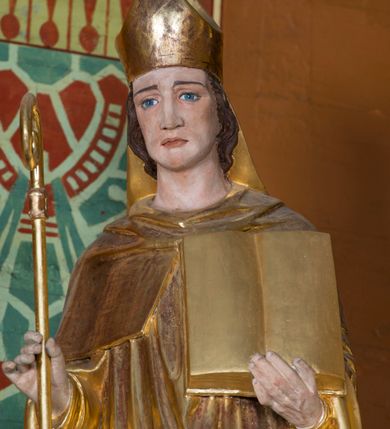 Zdjęcie nr 27: Kamienny ołtarz w jawiszowickim kościele uzyskał kształt prostopadłościanu. Otacza go drewniana obudowa podtrzymująca drewnianą mensę z portatylem. Jego przód zdobi drewniane antepedium ujęte profilowaną ramą z centralnym medalionem z monogramem Marii, otoczonym przez ornament roślinny. Ponad ołtarzem rozpościera się dwukondygnacyjna, architektoniczna nastawa ołtarzowa, flankowana przez dwie bramki. Struktura ołtarza dekorowana jest ciemnozieloną marmoryzacją. Pierwsza kondygnacja retabulum uzyskała trójosiowe założenie wsparte na dwustrefowym cokole, podzielonym płycinami z dekoracją akantową. Artykułują ją dwie pary kolumn o skręconych trzonach i kapitelach kompozytowych. Złocone w całości kolumny podtrzymują belkowanie o wysuniętym gzymsie, wyłamane na ich osi oraz przerwany trójkątny przyczółek. Pole środkowe nastawy wypełnia w całości nisza ujęta profilowaną, złoconą ramą w formie stojącego prostokąta zamkniętego trzema bokami z ośmioboku. W jej wnętrzu znajduje się obraz Matki Boskiej z Dzieciątkiem w typie Matki Boskiej Śnieżnej, zdobiony drewnianą złoconą i srebrzoną sukienką wotywną oraz koronami, a także dwie zasuwy z przedstawieniem św. Marcina, biskupa oraz bł. Salomei. Niszę środkową flankują znajdujące się pomiędzy kolumnami wąskie płyciny zwieńczone konchami. Na ich tle ustawiono figury św. Piotra i św. Pawła. Ponad nimi widoczne są na belkowaniu płaskorzeźbione i złocone girlandy kwiatowe oraz rozety. Na przerwanym przyczółku umieszczono dwie figury siedzących aniołów. Na mensie ołtarza centralnie ustawiono prostopadłościenne tabernakulum w drewnianej obudowie ujęte dwiema kolumienkami kompozytowymi o skręconych trzonach podtrzymujących belkowanie, do którego przymocowano świeczniki na sakramentki. Umieszczony na jego szczycie prosty tron eucharystyczny bez zaplecka flankują dwie figury uskrzydlonych aniołków. Drugą, jednoosiową kondygnację nastawy ujmuje także para złoconych kolumn o skręconych trzonach i kapitelach kompozytowych, ustawionych na cokołach, dźwigających imposty. Pomiędzy kolumnami nad polem z obrazem Wniebowzięcia Matki Boskiej widoczny jest wysunięty fragment gzymsu. Obraz ujęty został złoconą i profilowaną ramą w formie kwadratu o ściętych narożach. Po bokach obrazu na płycinie rozmieszczono złocone dekoracje akantowe. W zwieńczeniu na belkowaniu usytuowano dwa putta flankujące rzeźbę apokaliptycznego baranka leżącego na księdze. Obie kondygnacje ujmują uszaki z akantu suchego. Po bokach nastawy usytuowano dwie bramki flankowane pilastrami. Ich zwężające się ku dołowi trzony podtrzymują nadwieszony łuk półkolisty. Całość zamyka gzyms z centralnie usytuowanym cokołem, na którym stoją figury św. Stanisława i św. Wojciecha. Po ich bokach figur przy ścianach ustawiono rzeźbione i złocone wazony z kwiatami. 