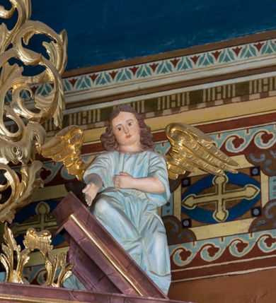 Zdjęcie nr 39: Kamienny ołtarz w jawiszowickim kościele uzyskał kształt prostopadłościanu. Otacza go drewniana obudowa podtrzymująca drewnianą mensę z portatylem. Jego przód zdobi drewniane antepedium ujęte profilowaną ramą z centralnym medalionem z monogramem Marii, otoczonym przez ornament roślinny. Ponad ołtarzem rozpościera się dwukondygnacyjna, architektoniczna nastawa ołtarzowa, flankowana przez dwie bramki. Struktura ołtarza dekorowana jest ciemnozieloną marmoryzacją. Pierwsza kondygnacja retabulum uzyskała trójosiowe założenie wsparte na dwustrefowym cokole, podzielonym płycinami z dekoracją akantową. Artykułują ją dwie pary kolumn o skręconych trzonach i kapitelach kompozytowych. Złocone w całości kolumny podtrzymują belkowanie o wysuniętym gzymsie, wyłamane na ich osi oraz przerwany trójkątny przyczółek. Pole środkowe nastawy wypełnia w całości nisza ujęta profilowaną, złoconą ramą w formie stojącego prostokąta zamkniętego trzema bokami z ośmioboku. W jej wnętrzu znajduje się obraz Matki Boskiej z Dzieciątkiem w typie Matki Boskiej Śnieżnej, zdobiony drewnianą złoconą i srebrzoną sukienką wotywną oraz koronami, a także dwie zasuwy z przedstawieniem św. Marcina, biskupa oraz bł. Salomei. Niszę środkową flankują znajdujące się pomiędzy kolumnami wąskie płyciny zwieńczone konchami. Na ich tle ustawiono figury św. Piotra i św. Pawła. Ponad nimi widoczne są na belkowaniu płaskorzeźbione i złocone girlandy kwiatowe oraz rozety. Na przerwanym przyczółku umieszczono dwie figury siedzących aniołów. Na mensie ołtarza centralnie ustawiono prostopadłościenne tabernakulum w drewnianej obudowie ujęte dwiema kolumienkami kompozytowymi o skręconych trzonach podtrzymujących belkowanie, do którego przymocowano świeczniki na sakramentki. Umieszczony na jego szczycie prosty tron eucharystyczny bez zaplecka flankują dwie figury uskrzydlonych aniołków. Drugą, jednoosiową kondygnację nastawy ujmuje także para złoconych kolumn o skręconych trzonach i kapitelach kompozytowych, ustawionych na cokołach, dźwigających imposty. Pomiędzy kolumnami nad polem z obrazem Wniebowzięcia Matki Boskiej widoczny jest wysunięty fragment gzymsu. Obraz ujęty został złoconą i profilowaną ramą w formie kwadratu o ściętych narożach. Po bokach obrazu na płycinie rozmieszczono złocone dekoracje akantowe. W zwieńczeniu na belkowaniu usytuowano dwa putta flankujące rzeźbę apokaliptycznego baranka leżącego na księdze. Obie kondygnacje ujmują uszaki z akantu suchego. Po bokach nastawy usytuowano dwie bramki flankowane pilastrami. Ich zwężające się ku dołowi trzony podtrzymują nadwieszony łuk półkolisty. Całość zamyka gzyms z centralnie usytuowanym cokołem, na którym stoją figury św. Stanisława i św. Wojciecha. Po ich bokach figur przy ścianach ustawiono rzeźbione i złocone wazony z kwiatami. 