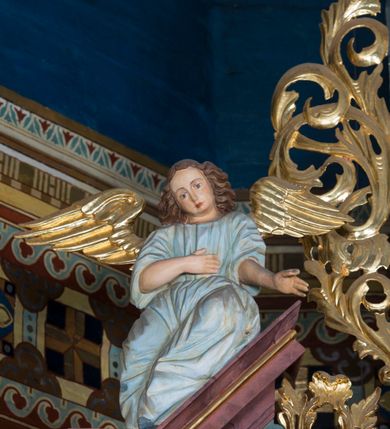 Zdjęcie nr 38: Kamienny ołtarz w jawiszowickim kościele uzyskał kształt prostopadłościanu. Otacza go drewniana obudowa podtrzymująca drewnianą mensę z portatylem. Jego przód zdobi drewniane antepedium ujęte profilowaną ramą z centralnym medalionem z monogramem Marii, otoczonym przez ornament roślinny. Ponad ołtarzem rozpościera się dwukondygnacyjna, architektoniczna nastawa ołtarzowa, flankowana przez dwie bramki. Struktura ołtarza dekorowana jest ciemnozieloną marmoryzacją. Pierwsza kondygnacja retabulum uzyskała trójosiowe założenie wsparte na dwustrefowym cokole, podzielonym płycinami z dekoracją akantową. Artykułują ją dwie pary kolumn o skręconych trzonach i kapitelach kompozytowych. Złocone w całości kolumny podtrzymują belkowanie o wysuniętym gzymsie, wyłamane na ich osi oraz przerwany trójkątny przyczółek. Pole środkowe nastawy wypełnia w całości nisza ujęta profilowaną, złoconą ramą w formie stojącego prostokąta zamkniętego trzema bokami z ośmioboku. W jej wnętrzu znajduje się obraz Matki Boskiej z Dzieciątkiem w typie Matki Boskiej Śnieżnej, zdobiony drewnianą złoconą i srebrzoną sukienką wotywną oraz koronami, a także dwie zasuwy z przedstawieniem św. Marcina, biskupa oraz bł. Salomei. Niszę środkową flankują znajdujące się pomiędzy kolumnami wąskie płyciny zwieńczone konchami. Na ich tle ustawiono figury św. Piotra i św. Pawła. Ponad nimi widoczne są na belkowaniu płaskorzeźbione i złocone girlandy kwiatowe oraz rozety. Na przerwanym przyczółku umieszczono dwie figury siedzących aniołów. Na mensie ołtarza centralnie ustawiono prostopadłościenne tabernakulum w drewnianej obudowie ujęte dwiema kolumienkami kompozytowymi o skręconych trzonach podtrzymujących belkowanie, do którego przymocowano świeczniki na sakramentki. Umieszczony na jego szczycie prosty tron eucharystyczny bez zaplecka flankują dwie figury uskrzydlonych aniołków. Drugą, jednoosiową kondygnację nastawy ujmuje także para złoconych kolumn o skręconych trzonach i kapitelach kompozytowych, ustawionych na cokołach, dźwigających imposty. Pomiędzy kolumnami nad polem z obrazem Wniebowzięcia Matki Boskiej widoczny jest wysunięty fragment gzymsu. Obraz ujęty został złoconą i profilowaną ramą w formie kwadratu o ściętych narożach. Po bokach obrazu na płycinie rozmieszczono złocone dekoracje akantowe. W zwieńczeniu na belkowaniu usytuowano dwa putta flankujące rzeźbę apokaliptycznego baranka leżącego na księdze. Obie kondygnacje ujmują uszaki z akantu suchego. Po bokach nastawy usytuowano dwie bramki flankowane pilastrami. Ich zwężające się ku dołowi trzony podtrzymują nadwieszony łuk półkolisty. Całość zamyka gzyms z centralnie usytuowanym cokołem, na którym stoją figury św. Stanisława i św. Wojciecha. Po ich bokach figur przy ścianach ustawiono rzeźbione i złocone wazony z kwiatami. 