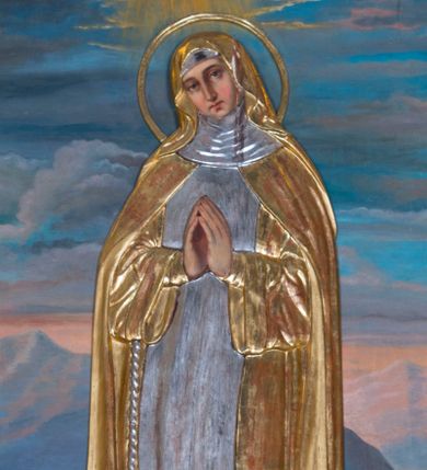 Zdjęcie nr 1: Obraz w kształcie wydłużonego prostokąta przedstawia stojącą w całej postaci w nieznacznym kontrapoście bł. Salomeę na tle górzystego krajobrazu. Błogosławiona została ukazana frontalne ze złożonymi na piersi dłońmi do modlitwy, z lekkim przechyleniem głowy w prawą stronę. Salomea ma pociągłą twarz o rumianych policzkach, wydatny prosty nos i mięsiste wargi. Jej głowę otacza kolisty nimb. Ubrana jest w strój klaryski z zakonnym welonem na głowie i podwiką pod szyją. Na ramionach ma narzucony płaszcz spięty pod szyją, odsłaniający habit ze szkaplerzem przewiązany w talii sznurem zakończonym krzyżykiem. Przy ziemi spod habitu widoczne są czubki butów. Całą postać okrywa drewniana, płaskorzeźbiona, złocona i srebrzona sukienka wotywna, która najprawdopodobniej powtarza pierwotny układ szat bł. Salomei. W lewym rogu obrazu u stóp błogosławionej leży złocona, drewniana korona zamknięta. Salomea stoi na trawiastym gruncie. Za nią rozpościera się górzysty krajobraz utrzymany w tonacji błękitno-różowej z widocznym fragmentem jeziora okrytego mgłą. Ponad górami przedstawiono niebo z bladoniebieskimi obłokami oraz wyraźnie zaznaczoną światłością jaśniejącą ponad głową błogosławionej.   