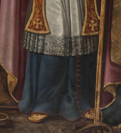 Zdjęcie nr 12: Obraz uzyskał kształt stojącego prostokąta. W centrum ukazano całopostaciowe przedstawienie św. Marcina z Tours jako biskupa. Święty został  wyobrażony frontalnie w nieznacznym kontrapoście z lekkim skłonem głowy w prawo. W lewej ręce trzyma pastorał, prawą natomiast unosi na wysokości piersi w geście błogosławieństwa. Jest to dojrzały mężczyzna o pociągłej twarzy otoczonej brązowym, kędzierzawym zarostem i włosami. Ma wyraziste oczy o spojrzeniu skierowanym ku górze, zmarszczone brwi, prosty, wydatny nos i usta. Ubrany jest w niebieską sutannę i mucet z czerwonymi guzikami i obszywkami. Spod rozpiętego od dołu mucetu widoczna jest biała komża z koronkowym obszyciem u spodu i cynobrowa stuła dekorowana ornamentem roślinnym. Nieznacznie rozszerzone końce stuły dekorują złociste krzyżyki. Na ramionach święty ma ubraną kapę liturgiczną, spod której widoczny jest na piersi złoty krzyż pektoralny. Cynobrowa kapa podbita jasnym fioletem spięta jest pod szyją kosztowną fibulą z klejnotem. Jej poły dekoruje złocisty ornament roślinny, a obramienia szeroka, złocista borta z motywem grzebykowania. Święty Marcin ma na głowie bladoniebieską infułę ze złocistym cirkulusem i podobnym obszyciem krańców zdobionych grzebykowaniem. Na środku infuły widoczny jest oprawiany w złoto klejnot. Jego głowę otacza świetlisty nimb przechodzący w jasną poświatę. Biskup na rękach ma ubrane cynobrowe rękawiczki pontyfikalne z rozszerzonymi limbusami zdobionymi krzyżykami równoramiennymi. Na serdecznym palcu prawej ręki widoczny jest pierścień biskupi z szafirem otoczonym brylancikami. Spod sutanny wystają czubki złocistych butów pontyfikalnych także zdobionych krzyżykami. Trzymany przez niego złoty pastorał zakończony jest krzywaśnią utworzoną z wygiętej wici akantowej z czteropłatkowym kwiatem w środku. W lewym dolnym rogu obrazu u stóp św. Marcina siedzi na kamiennych płytach pokrywających ziemię żebrak. Jego postać jest zmniejszona w stosunku do świętego. Jest to starszy mężczyzna o siwiejącym zaroście i włosach zaczesanych z przedziałkiem na środku głowy. Prawą ręką wspiera się o ziemię, przyciskając drewniany kostur. Lewą natomiast przykłada do piersi. Głowę i swoje spojrzenie kieruje w stronę stojącego biskupa. Żebrak ma pociągłą twarz o czole pokrytym zmarszczkami, wydatny, prosty nos i usta. Okrywa go jasnobrązowy łachman odsłaniający lewe ramię i fragment torsu. Przed nim leży na posadzce drewniane, płaskie naczynie z dłuższym uchwytem. Żebrak został ukazany na tle brunatnej ściany, której górną część okrywają jasnobrunatne i błękitnawe obłoki stanowiące tło dla postaci Marcina. Na obłokach z lewej strony widać nieproporcjonalnie małą postać Chrystusa. Zbawiciel siedząc na obłokach trzyma oparty o prawe ramię drewniany krzyż. Jego głowę otaczają brązowe włosy spływające na ramiona i broda. Twarz jest owalna z różowymi policzkami i wyraźnym nosem i ustami. Na jego dłoniach, boku i stopach widoczne są rany po męce. Postać Chrystusa okrywa czerwony, rozwiany całun odsłaniający jego nagi tors. U stóp Zbawiciela widoczne są dwie uskrzydlone główki aniołków o pucułowatych twarzach, rumianych policzkach i jasnych włosach. W prawym rogu obrazu u stóp św. Marcina leży charakterystycznie wygięty łuk, antyczny kirys oraz hełm ze szkarłatnym pióropuszem. Z tyłu widać bryłę kościoła z wyodrębnioną wieżą, nawą i prezbiterium, nakrytymi czerwoną dachówką.  