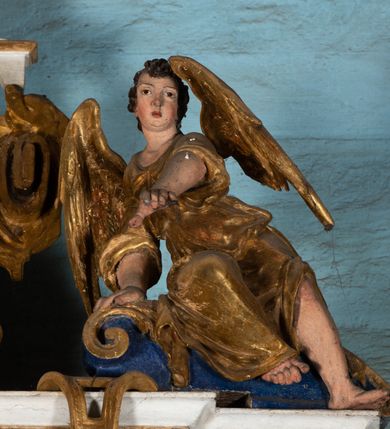 Zdjęcie nr 11: Epitafium uzyskało formę jednokondygnacyjnej, trójosiowej struktury architektonicznej z podstawą i zwieńczeniem, flankowanej po bokach fantazyjnymi uszakami. Część środkową tworzą trzy aedicule rozdzielone dwiema złoconymi kolumnami o korynckich kapitelach i trzonach dekorowanych festonami, a w dolnych partiach pierścieniami. Kolumny podtrzymują pełne belkowanie przechodzące przez całą szerokości kondygnacji, wyłamane nad osiami bocznymi. Same zaś stoją na cokole, który stanowi równocześnie wyłamany gzyms dla podstawy. Pole osi środkowej otrzymało kształt aediculi w formie stojącego prostokąta ze schodkowym zamknięciem u góry, wypełnionym ażurowym, złoconym maswerkiem. Jej wnętrze wypełnia płaskorzeźbione słońce pośród chmur na malowanym tle nieba. Poniżej ukazano panoramę Jerozolimy. Przed aediculą ustawiono na postumencie drewniany krzyż. Na osiach bocznych znalazły się nisze zwieńczone złotymi muszlami oraz złoconą, rytą ornamentyką z motywem czteroliścia. Pierwotnie znajdowały się tu rzeźby Mojżesza i Jana Chrzciciela. Całość po bokach flankują fantazyjne uszaki utworzone ornamentu rollwerkowego oraz z widocznych z profilu półpostaci maurów podtrzymujących belkowanie. Pole uszaków wypełniają pionowo ułożone owalne kartusze o czerwonych polach, stanowiące tło dla dwóch par tarczy herbowych z klejnotami. Z lewej umieszczono herb Dołęga, a z prawej herb Jastrzębiec (bez klejnotu). Po zewnętrznych stronach na belkowaniu ustawiono dwa półsiedzące uskrzydlone anioły (zachował się tylko anioł z prawej strony). Jednocześnie postacie aniołów flankują zwieńczenie epitafium, które tworzy aedicula wypełniona złotą muszlą oraz rytym złoconym ornamentem z motywem czteroliścia. Flankują ją dwa pilastry podtrzymujące wyłamane belkowanie na ich osi. W aediculi ustawiono pełnoplastyczną rzeźbę stojącej kobiety. Została ona ukazana w wydatnym kontrapoście z tułowiem skręconym w lewo, z głową ujętą w trzech czwartych w prawo. Kobieta w podniesionej prawej ręce trzyma srebrny kielich, natomiast w opuszczonej i wspartej o wysuniętą tanecznie lewą nogę otwartą księgę. Postać ma owalną twarz o jasnej karnacji i rumianych policzkach z prostym nosem i wydatnymi ustami. Jej głowę otaczają falujące, brązowe włosy opadające na plecy i  odsłaniające uszy. Ubrana jest w złoconą, mocno drapowaną suknię, która odsłania wysuniętą nogę. Po bokach pilastrów widoczne są dwa uszaki. Na szczycie zwieńczenia dwa pulchne putta prezentują chustę Weroniki, która została równocześnie przytwierdzona do wysokiego impostu wspierającego ażurowy, złocony kwiaton. Na chuście wyobrażono płaskorzeźbioną głowę Chrystusa w cierniowej koronie. Zbawiciel ma owalną twarz z szeroko otwartymi oczami, wydatnym nosem i półotwartymi ustami. Otaczają ją kręcone brązowe włosy oraz podobna, krótka broda. Podstawę epitafium tworzy wykrojona po bokach struktura, w której centrum umieszczono fantazyjnie wyciętą drewnianą, czarną tablicę ze złotym łacińskim napisem &quot;O HOMO FVI QVOD ES SVM QVOD ERIS / NVNC DE(M)VM VIVERE CO(E)PI, MORI DESII, VITA MIHI / PRIOR MORTE(M), MORS PRIA(M) VITA(M) SECV(N)DA(M), QVAE NU(N) QVA(M) / EST I(N)TERI TVRA DEDIT, MO(R)TALITATES  MEOR, HO(C) MIHI / EST ET VXORI MO(S) VENTV(S) POSVI, VIPOST QV(E)ALETHIVERA DVCEDI / NELVSOS, ET CARNIS EXVVIIS SO(L)VTOS  ABHOC PELAG  SECVRA / GLAVSTRA SVB IRE IVABIT, HIC MORTALE DIMIDIVM N(OST)RI, IMMORTA/LE(M) EXPECT ET IM(M)ORTALITATEM, E QVOS VITA CONIVCTOS TENVIT / MORS IDIVISOS CVSTODIRET, SI PIVS ES, PIAS PRECES ADDE, ET / HIC HV(M)O SVB HVMO QVIETA[M], ANIMAE IN COELESTI PATRIA / LETAM  QVIETEM APPRECARE &quot;NICOLAVS CORNITIVS DE / MAGNA POREMBA ET BEATA DE MIROW CONSOR/TES SE(M)PER VAIESL[?]&quot; / A(NNO) D(OMINI) 1611 P(ATRONVS) P(OSVIT)&quot;. Tablicę umieszczono w kartuszu rollwerkowym pomiędzy dwiema konsolami zdobionymi pierwotnie uskrzydlonymi główkami aniołków, podtrzymującymi belkowanie z krzyżem. Poniżej tablicy zastosowano odwrócony łuk odcinkowy z podwieszonym kartuszem rollwerkowym zawieszonym na festonach. W jego wnętrzu przedstawiono tabliczkę z napisem „VITA FUGIT VT HORA”, a po niżej trupią czaszkę ze skrzyżowanymi piszczelami.  
