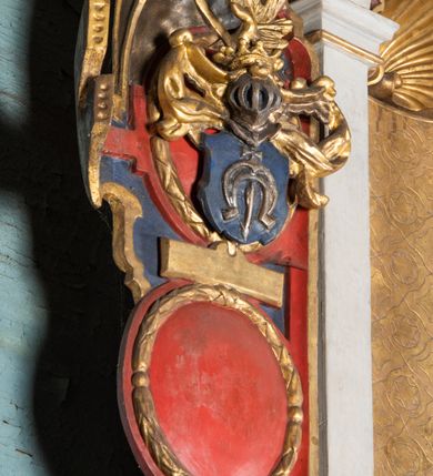 Zdjęcie nr 13: Epitafium uzyskało formę jednokondygnacyjnej, trójosiowej struktury architektonicznej z podstawą i zwieńczeniem, flankowanej po bokach fantazyjnymi uszakami. Część środkową tworzą trzy aedicule rozdzielone dwiema złoconymi kolumnami o korynckich kapitelach i trzonach dekorowanych festonami, a w dolnych partiach pierścieniami. Kolumny podtrzymują pełne belkowanie przechodzące przez całą szerokości kondygnacji, wyłamane nad osiami bocznymi. Same zaś stoją na cokole, który stanowi równocześnie wyłamany gzyms dla podstawy. Pole osi środkowej otrzymało kształt aediculi w formie stojącego prostokąta ze schodkowym zamknięciem u góry, wypełnionym ażurowym, złoconym maswerkiem. Jej wnętrze wypełnia płaskorzeźbione słońce pośród chmur na malowanym tle nieba. Poniżej ukazano panoramę Jerozolimy. Przed aediculą ustawiono na postumencie drewniany krzyż. Na osiach bocznych znalazły się nisze zwieńczone złotymi muszlami oraz złoconą, rytą ornamentyką z motywem czteroliścia. Pierwotnie znajdowały się tu rzeźby Mojżesza i Jana Chrzciciela. Całość po bokach flankują fantazyjne uszaki utworzone ornamentu rollwerkowego oraz z widocznych z profilu półpostaci maurów podtrzymujących belkowanie. Pole uszaków wypełniają pionowo ułożone owalne kartusze o czerwonych polach, stanowiące tło dla dwóch par tarczy herbowych z klejnotami. Z lewej umieszczono herb Dołęga, a z prawej herb Jastrzębiec (bez klejnotu). Po zewnętrznych stronach na belkowaniu ustawiono dwa półsiedzące uskrzydlone anioły (zachował się tylko anioł z prawej strony). Jednocześnie postacie aniołów flankują zwieńczenie epitafium, które tworzy aedicula wypełniona złotą muszlą oraz rytym złoconym ornamentem z motywem czteroliścia. Flankują ją dwa pilastry podtrzymujące wyłamane belkowanie na ich osi. W aediculi ustawiono pełnoplastyczną rzeźbę stojącej kobiety. Została ona ukazana w wydatnym kontrapoście z tułowiem skręconym w lewo, z głową ujętą w trzech czwartych w prawo. Kobieta w podniesionej prawej ręce trzyma srebrny kielich, natomiast w opuszczonej i wspartej o wysuniętą tanecznie lewą nogę otwartą księgę. Postać ma owalną twarz o jasnej karnacji i rumianych policzkach z prostym nosem i wydatnymi ustami. Jej głowę otaczają falujące, brązowe włosy opadające na plecy i  odsłaniające uszy. Ubrana jest w złoconą, mocno drapowaną suknię, która odsłania wysuniętą nogę. Po bokach pilastrów widoczne są dwa uszaki. Na szczycie zwieńczenia dwa pulchne putta prezentują chustę Weroniki, która została równocześnie przytwierdzona do wysokiego impostu wspierającego ażurowy, złocony kwiaton. Na chuście wyobrażono płaskorzeźbioną głowę Chrystusa w cierniowej koronie. Zbawiciel ma owalną twarz z szeroko otwartymi oczami, wydatnym nosem i półotwartymi ustami. Otaczają ją kręcone brązowe włosy oraz podobna, krótka broda. Podstawę epitafium tworzy wykrojona po bokach struktura, w której centrum umieszczono fantazyjnie wyciętą drewnianą, czarną tablicę ze złotym łacińskim napisem "O HOMO FVI QVOD ES SVM QVOD ERIS / NVNC DE(M)VM VIVERE CO(E)PI, MORI DESII, VITA MIHI / PRIOR MORTE(M), MORS PRIA(M) VITA(M) SECV(N)DA(M), QVAE NU(N) QVA(M) / EST I(N)TERI TVRA DEDIT, MO(R)TALITATES  MEOR, HO(C) MIHI / EST ET VXORI MO(S) VENTV(S) POSVI, VIPOST QV(E)ALETHIVERA DVCEDI / NELVSOS, ET CARNIS EXVVIIS SO(L)VTOS  ABHOC PELAG  SECVRA / GLAVSTRA SVB IRE IVABIT, HIC MORTALE DIMIDIVM N(OST)RI, IMMORTA/LE(M) EXPECT ET IM(M)ORTALITATEM, E QVOS VITA CONIVCTOS TENVIT / MORS IDIVISOS CVSTODIRET, SI PIVS ES, PIAS PRECES ADDE, ET / HIC HV(M)O SVB HVMO QVIETA[M], ANIMAE IN COELESTI PATRIA / LETAM  QVIETEM APPRECARE "NICOLAVS CORNITIVS DE / MAGNA POREMBA ET BEATA DE MIROW CONSOR/TES SE(M)PER VAIESL[?]" / A(NNO) D(OMINI) 1611 P(ATRONVS) P(OSVIT)". Tablicę umieszczono w kartuszu rollwerkowym pomiędzy dwiema konsolami zdobionymi pierwotnie uskrzydlonymi główkami aniołków, podtrzymującymi belkowanie z krzyżem. Poniżej tablicy zastosowano odwrócony łuk odcinkowy z podwieszonym kartuszem rollwerkowym zawieszonym na festonach. W jego wnętrzu przedstawiono tabliczkę z napisem „VITA FUGIT VT HORA”, a po niżej trupią czaszkę ze skrzyżowanymi piszczelami.  
