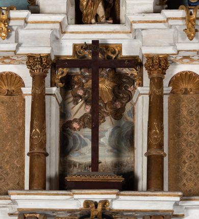 Zdjęcie nr 8: Epitafium uzyskało formę jednokondygnacyjnej, trójosiowej struktury architektonicznej z podstawą i zwieńczeniem, flankowanej po bokach fantazyjnymi uszakami. Część środkową tworzą trzy aedicule rozdzielone dwiema złoconymi kolumnami o korynckich kapitelach i trzonach dekorowanych festonami, a w dolnych partiach pierścieniami. Kolumny podtrzymują pełne belkowanie przechodzące przez całą szerokości kondygnacji, wyłamane nad osiami bocznymi. Same zaś stoją na cokole, który stanowi równocześnie wyłamany gzyms dla podstawy. Pole osi środkowej otrzymało kształt aediculi w formie stojącego prostokąta ze schodkowym zamknięciem u góry, wypełnionym ażurowym, złoconym maswerkiem. Jej wnętrze wypełnia płaskorzeźbione słońce pośród chmur na malowanym tle nieba. Poniżej ukazano panoramę Jerozolimy. Przed aediculą ustawiono na postumencie drewniany krzyż. Na osiach bocznych znalazły się nisze zwieńczone złotymi muszlami oraz złoconą, rytą ornamentyką z motywem czteroliścia. Pierwotnie znajdowały się tu rzeźby Mojżesza i Jana Chrzciciela. Całość po bokach flankują fantazyjne uszaki utworzone ornamentu rollwerkowego oraz z widocznych z profilu półpostaci maurów podtrzymujących belkowanie. Pole uszaków wypełniają pionowo ułożone owalne kartusze o czerwonych polach, stanowiące tło dla dwóch par tarczy herbowych z klejnotami. Z lewej umieszczono herb Dołęga, a z prawej herb Jastrzębiec (bez klejnotu). Po zewnętrznych stronach na belkowaniu ustawiono dwa półsiedzące uskrzydlone anioły (zachował się tylko anioł z prawej strony). Jednocześnie postacie aniołów flankują zwieńczenie epitafium, które tworzy aedicula wypełniona złotą muszlą oraz rytym złoconym ornamentem z motywem czteroliścia. Flankują ją dwa pilastry podtrzymujące wyłamane belkowanie na ich osi. W aediculi ustawiono pełnoplastyczną rzeźbę stojącej kobiety. Została ona ukazana w wydatnym kontrapoście z tułowiem skręconym w lewo, z głową ujętą w trzech czwartych w prawo. Kobieta w podniesionej prawej ręce trzyma srebrny kielich, natomiast w opuszczonej i wspartej o wysuniętą tanecznie lewą nogę otwartą księgę. Postać ma owalną twarz o jasnej karnacji i rumianych policzkach z prostym nosem i wydatnymi ustami. Jej głowę otaczają falujące, brązowe włosy opadające na plecy i  odsłaniające uszy. Ubrana jest w złoconą, mocno drapowaną suknię, która odsłania wysuniętą nogę. Po bokach pilastrów widoczne są dwa uszaki. Na szczycie zwieńczenia dwa pulchne putta prezentują chustę Weroniki, która została równocześnie przytwierdzona do wysokiego impostu wspierającego ażurowy, złocony kwiaton. Na chuście wyobrażono płaskorzeźbioną głowę Chrystusa w cierniowej koronie. Zbawiciel ma owalną twarz z szeroko otwartymi oczami, wydatnym nosem i półotwartymi ustami. Otaczają ją kręcone brązowe włosy oraz podobna, krótka broda. Podstawę epitafium tworzy wykrojona po bokach struktura, w której centrum umieszczono fantazyjnie wyciętą drewnianą, czarną tablicę ze złotym łacińskim napisem "O HOMO FVI QVOD ES SVM QVOD ERIS / NVNC DE(M)VM VIVERE CO(E)PI, MORI DESII, VITA MIHI / PRIOR MORTE(M), MORS PRIA(M) VITA(M) SECV(N)DA(M), QVAE NU(N) QVA(M) / EST I(N)TERI TVRA DEDIT, MO(R)TALITATES  MEOR, HO(C) MIHI / EST ET VXORI MO(S) VENTV(S) POSVI, VIPOST QV(E)ALETHIVERA DVCEDI / NELVSOS, ET CARNIS EXVVIIS SO(L)VTOS  ABHOC PELAG  SECVRA / GLAVSTRA SVB IRE IVABIT, HIC MORTALE DIMIDIVM N(OST)RI, IMMORTA/LE(M) EXPECT ET IM(M)ORTALITATEM, E QVOS VITA CONIVCTOS TENVIT / MORS IDIVISOS CVSTODIRET, SI PIVS ES, PIAS PRECES ADDE, ET / HIC HV(M)O SVB HVMO QVIETA[M], ANIMAE IN COELESTI PATRIA / LETAM  QVIETEM APPRECARE "NICOLAVS CORNITIVS DE / MAGNA POREMBA ET BEATA DE MIROW CONSOR/TES SE(M)PER VAIESL[?]" / A(NNO) D(OMINI) 1611 P(ATRONVS) P(OSVIT)". Tablicę umieszczono w kartuszu rollwerkowym pomiędzy dwiema konsolami zdobionymi pierwotnie uskrzydlonymi główkami aniołków, podtrzymującymi belkowanie z krzyżem. Poniżej tablicy zastosowano odwrócony łuk odcinkowy z podwieszonym kartuszem rollwerkowym zawieszonym na festonach. W jego wnętrzu przedstawiono tabliczkę z napisem „VITA FUGIT VT HORA”, a po niżej trupią czaszkę ze skrzyżowanymi piszczelami.  
