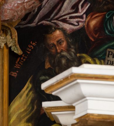 Zdjęcie nr 9: Obraz uzyskał formę stojącego prostokąta zamkniętego u góry łukiem odcinkowym nadwieszonym z uskokami, ujętego profilowaną ramą. W środkowej części kompozycji przedstawiono scenę zwiastowania Najświętszej Marii Pannie.
Marię ujętą w trzech czwartych w prawo wyobrażono klęczącą na klęczniku z lewej strony kompozycji. Lewą rękę przycisk do piersi, a prawą nieznacznie odsuwa od siebie. Jest to młoda dziewczyna po owalnej twarzy z jasną karnacją, wydatnym nosem i ustami z mocno drapowaną białą chusta na głowie zakrywającą jest włosy. Głowę Marii okala nimb. Madonna ubrań jest w bladofioletową suknię oraz ciemnozielony płaszcz nieznacznie zsuwający się z jej prawego ramienia, którego poła okrywa jej kolana. Na drewnianym klęczniku leży otwarta księga. Klęczący przed nią uskrzydlony Archanioł Gabriel ujęty w trzech czwartych w lewo klęczy na szarobiałych obłokach. Obiema rękami prezentuje Marii pergaminowy list zakończony u dołu zawieszoną na przytwierdzonych do jego rogów sznurku okrągłą, woskową pieczęcią zdobioną symbolem Trójcy Świętej. Na liście umieszczono kaligraficzne wypisane pozdrowienie anielskie: „AVE MARIA GRA/TIA PLENA DOMINVS / TECVM BENEDICTA TV / IN MVLIERIBVS ET / BENEDICTVS TRV/CTVS [FRVCTVS] VENTRIS TVI / JESVS CHRISTVS”. Jego młodzieńcza twarz o jasnej karnacji z wydatnym nosem i ustami widoczna jest z profilu. Otaczają ją falujące brązowe włosy, spływające na jego plecy spod złotego diademu dekorowanego na przędzie klejnotem z krzyżykiem. Gabriel ubrany jest w jasną tunikę dekorowaną drobnymi kwiatuszkami oraz złocistą szatę z podwiniętymi rękawami opadającą na jego plecy i przewiązaną skrzyżowaną na piersi ciemnozieloną stułą o końcach zdobionych złotymi chwostami. Pomiędzy obłokami na których klęczy archanioł widoczne są uskrzydlone główki anielskie. W górnej części kompozycji widać otwarte niebiosa okolone po zewnętrznej niebieskoszarymi obłokami z igrającymi w nich aniołkami adorującymi widocznego w połowie na obłoku Boga Ojca. Stworzyciel został ukazany na jasnym tle utworzonym z niezliczonej liczby ułożonych koncentrycznie uskrzydlonych główek anielskich. Bóg Ojciec został ujęty frontalnie z uniesioną prawą ręką oraz niebieskim globem podtrzymywanym lewą na szaroniebieskim obłoku. Jest to starzec z obfitą siwą brodą i włosami oraz zamkniętymi oczami. Ubrany jest w ciemnoniebieską tunikę oraz przerzucony prze lewe ramię bladoszkarłatny płaszcz. Poniże ponad głowami Marii i Archanioła w świetlanym otoku przedstawiono gołębicę Ducha Świętego, od której snop świtała pada na Marię. W dolnej części kompozycji wyobrażono siedzących sześciu proroków i królów starotestamentalnych trzymających prostokątne tablice z napisami. Widoczny w centrum król Dawid gra na złocistej harfie. Są to starsi mężczyźni w orientalnych strojach. Dwóch z nich ma złote korony, dwóch wzorzyste turbany, a dwaj pozostali mają głowy okryte tkaninami. Ich twarze okalają siwe brody, bądź też krótkie brody brązowe. W prawym dolnym rogu widoczna jest sygnatura „B. Weiss 1896.”