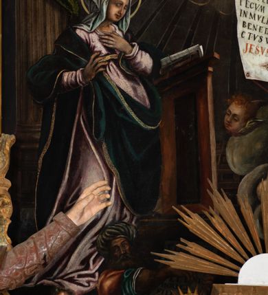 Zdjęcie nr 10: Obraz uzyskał formę stojącego prostokąta zamkniętego u góry łukiem odcinkowym nadwieszonym z uskokami, ujętego profilowaną ramą. W środkowej części kompozycji przedstawiono scenę zwiastowania Najświętszej Marii Pannie.
Marię ujętą w trzech czwartych w prawo wyobrażono klęczącą na klęczniku z lewej strony kompozycji. Lewą rękę przycisk do piersi, a prawą nieznacznie odsuwa od siebie. Jest to młoda dziewczyna po owalnej twarzy z jasną karnacją, wydatnym nosem i ustami z mocno drapowaną białą chusta na głowie zakrywającą jest włosy. Głowę Marii okala nimb. Madonna ubrań jest w bladofioletową suknię oraz ciemnozielony płaszcz nieznacznie zsuwający się z jej prawego ramienia, którego poła okrywa jej kolana. Na drewnianym klęczniku leży otwarta księga. Klęczący przed nią uskrzydlony Archanioł Gabriel ujęty w trzech czwartych w lewo klęczy na szarobiałych obłokach. Obiema rękami prezentuje Marii pergaminowy list zakończony u dołu zawieszoną na przytwierdzonych do jego rogów sznurku okrągłą, woskową pieczęcią zdobioną symbolem Trójcy Świętej. Na liście umieszczono kaligraficzne wypisane pozdrowienie anielskie: „AVE MARIA GRA/TIA PLENA DOMINVS / TECVM BENEDICTA TV / IN MVLIERIBVS ET / BENEDICTVS TRV/CTVS [FRVCTVS] VENTRIS TVI / JESVS CHRISTVS”. Jego młodzieńcza twarz o jasnej karnacji z wydatnym nosem i ustami widoczna jest z profilu. Otaczają ją falujące brązowe włosy, spływające na jego plecy spod złotego diademu dekorowanego na przędzie klejnotem z krzyżykiem. Gabriel ubrany jest w jasną tunikę dekorowaną drobnymi kwiatuszkami oraz złocistą szatę z podwiniętymi rękawami opadającą na jego plecy i przewiązaną skrzyżowaną na piersi ciemnozieloną stułą o końcach zdobionych złotymi chwostami. Pomiędzy obłokami na których klęczy archanioł widoczne są uskrzydlone główki anielskie. W górnej części kompozycji widać otwarte niebiosa okolone po zewnętrznej niebieskoszarymi obłokami z igrającymi w nich aniołkami adorującymi widocznego w połowie na obłoku Boga Ojca. Stworzyciel został ukazany na jasnym tle utworzonym z niezliczonej liczby ułożonych koncentrycznie uskrzydlonych główek anielskich. Bóg Ojciec został ujęty frontalnie z uniesioną prawą ręką oraz niebieskim globem podtrzymywanym lewą na szaroniebieskim obłoku. Jest to starzec z obfitą siwą brodą i włosami oraz zamkniętymi oczami. Ubrany jest w ciemnoniebieską tunikę oraz przerzucony prze lewe ramię bladoszkarłatny płaszcz. Poniże ponad głowami Marii i Archanioła w świetlanym otoku przedstawiono gołębicę Ducha Świętego, od której snop świtała pada na Marię. W dolnej części kompozycji wyobrażono siedzących sześciu proroków i królów starotestamentalnych trzymających prostokątne tablice z napisami. Widoczny w centrum król Dawid gra na złocistej harfie. Są to starsi mężczyźni w orientalnych strojach. Dwóch z nich ma złote korony, dwóch wzorzyste turbany, a dwaj pozostali mają głowy okryte tkaninami. Ich twarze okalają siwe brody, bądź też krótkie brody brązowe. W prawym dolnym rogu widoczna jest sygnatura „B. Weiss 1896.”