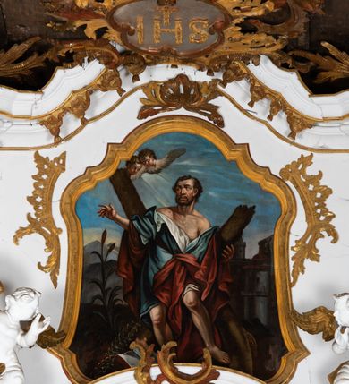 Zdjęcie nr 18: Kamienny ołtarz zamknięto w drewnianej obudowie, nakrywając go  drewnianą mensą z portatylem. Stipes ołtarzowy uzyskał kształt prostopadłościanu. Jego przód zdobi drewniane antepedium ujęte profilowaną ramą z malowanym chrystogramem "IHS" w glorii w polu. Na mensie ołtarza usytuowano tabernakulum w formie stojącego prostopadłościanu o wypukłym froncie i wklęsłych bokach wspierającego się na cokole. Jego przód ujmuje para kolumn podtrzymujących niepełne belkowanie, wyłamane nad ścianą frontową na kształt łuku odcinkowego nadwieszonego. Na froncie zamontowano obrotową, dwustronną niszę ujętą ramą w formie stojącego prostokąta zamkniętego łukiem półkolistym, wielolistnym. Nisze bębna zwieńczone zostały złoconymi konchami. Na tabernakulum usytuowano tron eucharystyczny w formie cokołu z leżącą księgą o siedmiu pieczęciach w glorii. Retabulum ołtarzowe wzniesiono na planie półowalu i polichromowano je na biało. Jest to architektoniczna, jednokondygnacyjna, jednoosiowa struktura ze zwieńczeniem. Po bokach flankują ją bramki ustawione na dwustrefowym, tralkowym, wklęsło-wypukłym cokole. Kondygnacja została ujęta dwiema parami pilastrów zwróconych delikatnie do wewnątrz oraz silnie wysuniętą do przodu parą kolumn o kapitelach kompozytowych. Podpory dźwigają pełne belkowanie o wklęsło-wypukłej linii. Nad polem środkowym belkowanie jest połączone gzymsem przyjmującym formę łuku falistego i wyłamane na osiach podpór. Kondygnacje ujmują spływy wolutowe połączone z łukowato wygiętymi wolutami podtrzymywanymi przez wysokie tralkowe cokoły, tworząc bramki ołtarza. W polu środkowym umieszczono obraz Zwiastowania ujęty profilowaną, złoconą ramą w formie stojącego prostokąta zamkniętego łukiem półkolistym nadwieszonym z uskokiem. Zwieńczenie uzyskało formę leżącego prostokąta flankowanego parą pilastrów zwróconych do wewnątrz oraz parą pilastrów zwróconych na zewnątrz, których trzony przechodzą w spływy wolutowe opadające na belkowanie. Pilastry dźwigają niepełne, wklęsło-wypukłe belkowanie przyjmujące nad polem formę łuku falistego. Całość wieńczy kartusz rokokowy z chrystogramem "IHS". W polu zwieńczenia znalazł się obraz św. Andrzeja w profilowanej, złoconej ramie o fantazyjnej formie zbliżonej do stojącego prostokąta. Pilastry kondygnacji ozdobiono kapitelami z rocaille'ów, a ich trzony udekorowano złoconymi, rokokowymi panneau ze zwisami utworzonymi z rocaille'ów, rozet i liści. Na ich tle usytuowano figury świętego króla i św. Jana Chrzciciela. Rzeźby stoją na górnej strefie cokołu na wspornikach z rocaille. Na ramie obrazu w polu środkowym, w przyłuczach i na belkowaniu znalazły się ornamenty roślinne. Z kolei na wolutowych łukach bramek umieszczono rokokowe wazony oraz pary figur aniołów z kartuszami. Na belkowaniu i wolutach zwieńczenia znajdują się dwie pary puttów. Także trzony pilastrów zwieńczenia dekorowane są złoconymi zwisami z rocaille'ów i kwiatów. Pole wokół obrazu św. Andrzeja zostało ozdobione fragmentami rocaille'ów. Pod gzymsem koronującym powyżej obrazu, podwieszono lambrekin, zdobiony przy górnej krawędzi złoconymi liśćmi i rocaille'm. 