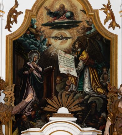 Zdjęcie nr 2: Kamienny ołtarz zamknięto w drewnianej obudowie, nakrywając go  drewnianą mensą z portatylem. Stipes ołtarzowy uzyskał kształt prostopadłościanu. Jego przód zdobi drewniane antepedium ujęte profilowaną ramą z malowanym chrystogramem &quot;IHS&quot; w glorii w polu. Na mensie ołtarza usytuowano tabernakulum w formie stojącego prostopadłościanu o wypukłym froncie i wklęsłych bokach wspierającego się na cokole. Jego przód ujmuje para kolumn podtrzymujących niepełne belkowanie, wyłamane nad ścianą frontową na kształt łuku odcinkowego nadwieszonego. Na froncie zamontowano obrotową, dwustronną niszę ujętą ramą w formie stojącego prostokąta zamkniętego łukiem półkolistym, wielolistnym. Nisze bębna zwieńczone zostały złoconymi konchami. Na tabernakulum usytuowano tron eucharystyczny w formie cokołu z leżącą księgą o siedmiu pieczęciach w glorii. Retabulum ołtarzowe wzniesiono na planie półowalu i polichromowano je na biało. Jest to architektoniczna, jednokondygnacyjna, jednoosiowa struktura ze zwieńczeniem. Po bokach flankują ją bramki ustawione na dwustrefowym, tralkowym, wklęsło-wypukłym cokole. Kondygnacja została ujęta dwiema parami pilastrów zwróconych delikatnie do wewnątrz oraz silnie wysuniętą do przodu parą kolumn o kapitelach kompozytowych. Podpory dźwigają pełne belkowanie o wklęsło-wypukłej linii. Nad polem środkowym belkowanie jest połączone gzymsem przyjmującym formę łuku falistego i wyłamane na osiach podpór. Kondygnacje ujmują spływy wolutowe połączone z łukowato wygiętymi wolutami podtrzymywanymi przez wysokie tralkowe cokoły, tworząc bramki ołtarza. W polu środkowym umieszczono obraz Zwiastowania ujęty profilowaną, złoconą ramą w formie stojącego prostokąta zamkniętego łukiem półkolistym nadwieszonym z uskokiem. Zwieńczenie uzyskało formę leżącego prostokąta flankowanego parą pilastrów zwróconych do wewnątrz oraz parą pilastrów zwróconych na zewnątrz, których trzony przechodzą w spływy wolutowe opadające na belkowanie. Pilastry dźwigają niepełne, wklęsło-wypukłe belkowanie przyjmujące nad polem formę łuku falistego. Całość wieńczy kartusz rokokowy z chrystogramem &quot;IHS&quot;. W polu zwieńczenia znalazł się obraz św. Andrzeja w profilowanej, złoconej ramie o fantazyjnej formie zbliżonej do stojącego prostokąta. Pilastry kondygnacji ozdobiono kapitelami z rocaille&#039;ów, a ich trzony udekorowano złoconymi, rokokowymi panneau ze zwisami utworzonymi z rocaille&#039;ów, rozet i liści. Na ich tle usytuowano figury świętego króla i św. Jana Chrzciciela. Rzeźby stoją na górnej strefie cokołu na wspornikach z rocaille. Na ramie obrazu w polu środkowym, w przyłuczach i na belkowaniu znalazły się ornamenty roślinne. Z kolei na wolutowych łukach bramek umieszczono rokokowe wazony oraz pary figur aniołów z kartuszami. Na belkowaniu i wolutach zwieńczenia znajdują się dwie pary puttów. Także trzony pilastrów zwieńczenia dekorowane są złoconymi zwisami z rocaille&#039;ów i kwiatów. Pole wokół obrazu św. Andrzeja zostało ozdobione fragmentami rocaille&#039;ów. Pod gzymsem koronującym powyżej obrazu, podwieszono lambrekin, zdobiony przy górnej krawędzi złoconymi liśćmi i rocaille&#039;m. 