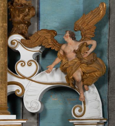 Zdjęcie nr 21: Kamienny ołtarz zamknięto w drewnianej obudowie, nakrywając go  drewnianą mensą z portatylem. Stipes ołtarzowy uzyskał kształt prostopadłościanu. Jego przód zdobi drewniane antepedium ujęte profilowaną ramą z malowanym chrystogramem &quot;IHS&quot; w glorii w polu. Na mensie ołtarza usytuowano tabernakulum w formie stojącego prostopadłościanu o wypukłym froncie i wklęsłych bokach wspierającego się na cokole. Jego przód ujmuje para kolumn podtrzymujących niepełne belkowanie, wyłamane nad ścianą frontową na kształt łuku odcinkowego nadwieszonego. Na froncie zamontowano obrotową, dwustronną niszę ujętą ramą w formie stojącego prostokąta zamkniętego łukiem półkolistym, wielolistnym. Nisze bębna zwieńczone zostały złoconymi konchami. Na tabernakulum usytuowano tron eucharystyczny w formie cokołu z leżącą księgą o siedmiu pieczęciach w glorii. Retabulum ołtarzowe wzniesiono na planie półowalu i polichromowano je na biało. Jest to architektoniczna, jednokondygnacyjna, jednoosiowa struktura ze zwieńczeniem. Po bokach flankują ją bramki ustawione na dwustrefowym, tralkowym, wklęsło-wypukłym cokole. Kondygnacja została ujęta dwiema parami pilastrów zwróconych delikatnie do wewnątrz oraz silnie wysuniętą do przodu parą kolumn o kapitelach kompozytowych. Podpory dźwigają pełne belkowanie o wklęsło-wypukłej linii. Nad polem środkowym belkowanie jest połączone gzymsem przyjmującym formę łuku falistego i wyłamane na osiach podpór. Kondygnacje ujmują spływy wolutowe połączone z łukowato wygiętymi wolutami podtrzymywanymi przez wysokie tralkowe cokoły, tworząc bramki ołtarza. W polu środkowym umieszczono obraz Zwiastowania ujęty profilowaną, złoconą ramą w formie stojącego prostokąta zamkniętego łukiem półkolistym nadwieszonym z uskokiem. Zwieńczenie uzyskało formę leżącego prostokąta flankowanego parą pilastrów zwróconych do wewnątrz oraz parą pilastrów zwróconych na zewnątrz, których trzony przechodzą w spływy wolutowe opadające na belkowanie. Pilastry dźwigają niepełne, wklęsło-wypukłe belkowanie przyjmujące nad polem formę łuku falistego. Całość wieńczy kartusz rokokowy z chrystogramem &quot;IHS&quot;. W polu zwieńczenia znalazł się obraz św. Andrzeja w profilowanej, złoconej ramie o fantazyjnej formie zbliżonej do stojącego prostokąta. Pilastry kondygnacji ozdobiono kapitelami z rocaille&#039;ów, a ich trzony udekorowano złoconymi, rokokowymi panneau ze zwisami utworzonymi z rocaille&#039;ów, rozet i liści. Na ich tle usytuowano figury świętego króla i św. Jana Chrzciciela. Rzeźby stoją na górnej strefie cokołu na wspornikach z rocaille. Na ramie obrazu w polu środkowym, w przyłuczach i na belkowaniu znalazły się ornamenty roślinne. Z kolei na wolutowych łukach bramek umieszczono rokokowe wazony oraz pary figur aniołów z kartuszami. Na belkowaniu i wolutach zwieńczenia znajdują się dwie pary puttów. Także trzony pilastrów zwieńczenia dekorowane są złoconymi zwisami z rocaille&#039;ów i kwiatów. Pole wokół obrazu św. Andrzeja zostało ozdobione fragmentami rocaille&#039;ów. Pod gzymsem koronującym powyżej obrazu, podwieszono lambrekin, zdobiony przy górnej krawędzi złoconymi liśćmi i rocaille&#039;m. 