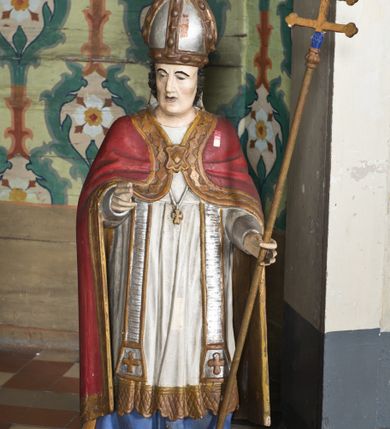 Zdjęcie nr 3: Nastawa ołtarzowa na planie półowalu uzyskała architektoniczną, jednokondygnacyjną strukturę ze zwieńczeniem. Jednoosiowe retabulum flankowane bramkami, na których ustawiono figury św. Wojciecha i św. Stanisława. Stipes ołtarz ujmuje drewniana prostopadłościenna obudowa podtrzymująca drewnianą mensą z portatylem. Drewniane antependium ujęte zostało czworoboczną, profilowaną ramą z płaskorzeźbionym i złoconym barankiem apokaliptycznym leżącym na księdze. Na mensie ustawiono współczesne tabernakulum pancerne w formie prostopadłościennej skrzynki. Kondygnacja retabulum ujęta została dwiema parami pilastrów zwróconych delikatnie do wewnątrz oraz silnie wysuniętą do przodu parą kolumn o kapitelach kompozytowych oraz dwie wolutowe konsole. Podpory dźwigają pełne belkowanie wsparte na impostach, o wklęsło-wypukłej linii. Nad polem środkowym widoczne jest połączenie wyłącznie gzymsem przyjmującym formę łuku falistego, wyłamane na osiach podpór. Na środku belkowania umieszczono kartusz, od którego odchodzą dwie girland kwiatowe. Kondygnacje ujmują zredukowane do wici akantowej uszaki. W polu środkowym usytuowano obraz św. Wawrzyńca ujęty profilowaną ramą w formie stojącego prostokąta zamkniętego łukiem nadwieszonym. Zwieńczenie nastawy uzyskało formę leżącego prostokąta flankowanego dwoma spływami wolutowymi opadającymi na belkowanie. Obie woluty dźwigają niepełne, wklęsło-wypukłe belkowanie przyjmujące nad polem formę łuku falistego. W centrum zwieńczenia umieszczono rzeźbioną grupę ze sceną koronacji Marii w srebrzonych obłokach z promieniami. Struktura nastawy jest polichromowana w kolorze białym, kolumny, konsole, profile i ornamentyka pierwotnie były złocone.