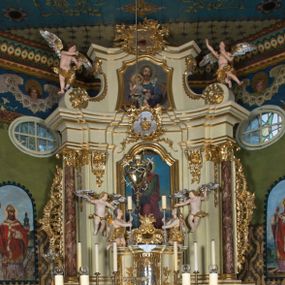 Zdjęcie nr 1: Nastawa ołtarzowa jest architektoniczna, jednoosiowa, jednokondygnacyjna ze zwieńczeniem, ustawiona na wysokim cokole. Ołtarz jest murowany, prostopadłościenny z marmurową mensą z portatylem. Trzy boki ołtarza ujmują malowane na płótnie obrazy w profilowanych, polichromowanych ramach. W polu antepedium znajduje się wyobrażenie architektonicznej nastawy z przedstawieniem baranka na ołtarzu, którą flankują sylwetki św. Piotra i św. Pawła.Tabernakulum ołtarza w formie metalowej skrzynki o wypukłym froncie i drewnianej obudowie w postaci wklęsłych boków zamkniętych parą pilastrów, których trzony przechodzą w spływy wolutowe. Podpory dźwigają profilowany gzyms przebiegający przez całą szerokość tabernakulum, nad frontem dekorowany lambrekinem. Metalowe drzwiczki mają kształt stojącego prostokąta zamkniętego łukiem półkolistym z aplikacjami w postaci kielicha z hostią w glorii, kłosami zbóż i winnego grona. Ponad drzwiczkami znajduje się kartusz z przedstawieniem pelikana. Na tabernakulum umiejscowiony jest tron wystawienia  w formie rzeźbionego ornamentalnego tła, flankowany przez parę rzeźbionych aniołów trzymających lichtarze. Retabulum ujęte jest parą opilastrowanych filarów i parą stojących przed nimi kolumn o kapitelach kompozytowych ustawionych pod kątem względem lica ołtarza. Podpory dźwigają wyłamujące się ponad nimi belkowanie z przerwanymi nad polem środkowym architrawem i fryzem. Zwieńczenie flankuje para spływów wolutowych, zamyka fragment wyłamanego na końcach gzymsu. Retabulum ujmuje para ażurowych, rocaille'owych uszaków, a w zwieńczeniu para figur adorujących aniołów. Trzony pilastrów zdobią rocaille'owe zwisy. W polu środkowym retabulum jest wnęka w formie stojącego prostokąta zamkniętego uskokowym, nadwieszonym łukiem półkolistym, ujęta profilowaną ramą. Wewnątrz znajduje się obraz Matki Boskiej z Dzieciątkiem. Powyżej, pośrodku belkowania umieszczono rocaille'owy kartusz z płaskorzeźbioną, zamkniętą koroną w polu. W zwieńczeniu jest obraz św. Józefa w profilowanej ramie w kształcie zbliżonym do stojącego prostokąta zamkniętego łukiem segmentowym z uskokiem oraz wklęsłymi dolnymi narożami. Szczyt ma formę rokokowego kartusza z malowanym okiem Opatrzności. Na zdobionych motywami rocaille'owymi wolutach spływów znajduje się para aniołów. 

Struktura ołtarza jest polichromowana w kolorze beżowym, trzony kolumn marmoryzowane, ornamentyka i profile złocone. 
