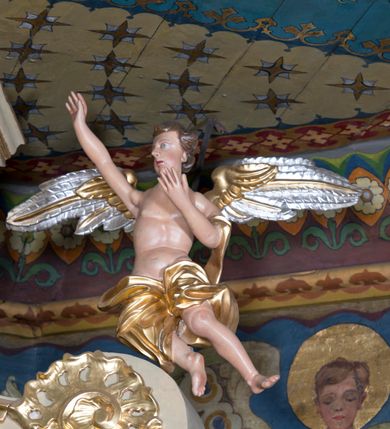 Zdjęcie nr 10: Nastawa ołtarzowa jest architektoniczna, jednoosiowa, jednokondygnacyjna ze zwieńczeniem, ustawiona na wysokim cokole. Ołtarz jest murowany, prostopadłościenny z marmurową mensą z portatylem. Trzy boki ołtarza ujmują malowane na płótnie obrazy w profilowanych, polichromowanych ramach. W polu antepedium znajduje się wyobrażenie architektonicznej nastawy z przedstawieniem baranka na ołtarzu, którą flankują sylwetki św. Piotra i św. Pawła.Tabernakulum ołtarza w formie metalowej skrzynki o wypukłym froncie i drewnianej obudowie w postaci wklęsłych boków zamkniętych parą pilastrów, których trzony przechodzą w spływy wolutowe. Podpory dźwigają profilowany gzyms przebiegający przez całą szerokość tabernakulum, nad frontem dekorowany lambrekinem. Metalowe drzwiczki mają kształt stojącego prostokąta zamkniętego łukiem półkolistym z aplikacjami w postaci kielicha z hostią w glorii, kłosami zbóż i winnego grona. Ponad drzwiczkami znajduje się kartusz z przedstawieniem pelikana. Na tabernakulum umiejscowiony jest tron wystawienia  w formie rzeźbionego ornamentalnego tła, flankowany przez parę rzeźbionych aniołów trzymających lichtarze. Retabulum ujęte jest parą opilastrowanych filarów i parą stojących przed nimi kolumn o kapitelach kompozytowych ustawionych pod kątem względem lica ołtarza. Podpory dźwigają wyłamujące się ponad nimi belkowanie z przerwanymi nad polem środkowym architrawem i fryzem. Zwieńczenie flankuje para spływów wolutowych, zamyka fragment wyłamanego na końcach gzymsu. Retabulum ujmuje para ażurowych, rocaille'owych uszaków, a w zwieńczeniu para figur adorujących aniołów. Trzony pilastrów zdobią rocaille'owe zwisy. W polu środkowym retabulum jest wnęka w formie stojącego prostokąta zamkniętego uskokowym, nadwieszonym łukiem półkolistym, ujęta profilowaną ramą. Wewnątrz znajduje się obraz Matki Boskiej z Dzieciątkiem. Powyżej, pośrodku belkowania umieszczono rocaille'owy kartusz z płaskorzeźbioną, zamkniętą koroną w polu. W zwieńczeniu jest obraz św. Józefa w profilowanej ramie w kształcie zbliżonym do stojącego prostokąta zamkniętego łukiem segmentowym z uskokiem oraz wklęsłymi dolnymi narożami. Szczyt ma formę rokokowego kartusza z malowanym okiem Opatrzności. Na zdobionych motywami rocaille'owymi wolutach spływów znajduje się para aniołów. 

Struktura ołtarza jest polichromowana w kolorze beżowym, trzony kolumn marmoryzowane, ornamentyka i profile złocone. 
