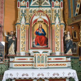 Zdjęcie nr 1: Ołtarz Najświętszego Serca Pana Jezusa uzyskał formę drewnianej i polichromowanej przyściennej struktury architektonicznej. Jest to założenie jednoosiowe i jednokondygnacyjne ze zwieńczeniem. Drewniana mensa wspiera się na prostopadłościennym drewnianym stipesie ołtarzowym flankowanym po bokach kolumienkami na wysokich cokolikach. Antepedium zostało podzielone obramionymi podłużnymi dwiema płycinami. Ich wewnętrzne krótsze boki są wklęsłe. W centrum pomiędzy płycinami znajduje się złocony czteroliść w owalu z wpisanym w środku krzyżem równoramiennym. Nastawa została ustawiona na zdwojonym cokole z przylegającym do niego na środku wielobocznym tabernakulum. Prostopadłościenne tabernakulum o ściętych narożach dekorowane jest płycinami ozdobionymi przenikającymi się ostrołukami z noskami. Drzwiczki zdobią litery alfa i omega. Górną część tabernakulum zamyka profilowany gzyms, natomiast dolną dekoruje pseudogotycki fryz z motywem czteroliścia wpisanego w romboidalną kratownicę. Podobny fryz znajduje się w dolnej cześć cokołu nastawy. Z kolei górną zdobią podłużne płyciny ze złoconą dekoracją maswerkową. Z cokołu wyrasta architektoniczna struktura utworzona z centralnej aediculi flankowanej parami kolumn o korynckich, złoconych kapitelach i czerwonych trzonach dekorowanych złotym ornamentem geometrycznym. Kolumny zostały ustawione na niewielkich postumentach. Podtrzymują one imposty z cokolikami z rozetami, z których wyrastają złocone, skręcone mniejsze kolumienki z fantazyjnymi kapitelami podtrzymującymi czworoboczne sterczyny przechodzące w pinakle zwieńczone kwiatonami. W dolnej części pomiędzy kolumnami zastosowano wydłużone płyciny zwieńczone trójbocznie z wpisanymi ostrołukami, wypełnionymi złoconym ornamentem astwerkowym. Natomiast w górnej części pomiędzy skręconymi kolumienkami oraz w tle arkady wieńczącej aediculę zastosowano płyciny dekorowane złoconymi ostrołukami z noskami. Ponad bocznymi płycinami wypiętrzono po bokach dwa mniejsze trójkątne szczyty zakończone pinaklami. Większy trójkątny szczyt, wypełniony obrazem z przedstawieniem Niepokalanego Serca Najświętszej Marii Panny, wznosi się nad centralną aediculą zakończoną ostrołukowo. W górnej części ostrołuk aediculi wypełnia ażurowy fantazyjny maswerk. W aediculi znajduje się obraz Najświętszego Serca Pana Jezusa, a na zasuwach obraz Matki Boskiej Różańcowej i św. Barbary. Nastawę po bokach flankują pełnoplastyczne figury św. Dominika oraz św. Katarzyny Sieneńskiej. Całość polichromowana jest w odcieniach seledynowej zieleni, rozbielonej czerwieni oraz błękintawej szarości. Partie ornamentów i profile płycin są złocone.