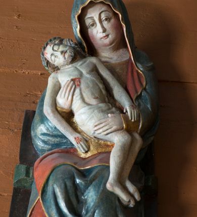 Zdjęcie nr 8: Pieta w Jawiszowicach reprezentuje Pietę w tzw. typie Pieta corpusculum. Przedstawiono tutaj pełnopostaciową figurę siedzącej Marii, trzymającą na kolanach martwe ciało Chrystusa. Matka Boska jest lekko pochylona w prawą stronę. Obiema rękami podtrzymuje na swoich kolanach Chrystusa, opartego o jej prawe przedramię. Prawą ręką trzyma go za bok, a lewą kładzie na jego udach. Ma owalną twarz o jasnej karnacji z wysokim czołem. Jej oczy są duże, wyraźne. Maria ma długi, prosty nos, czerwone usta, rumiane policzki i nieznacznie zaznaczone zmarszczki podkreślające jej cierpienie. Matka Boska odziana jest w złotą tunikę i ciemnobłękitny maforion z czerwonym podbiciem lamowany złotem, okrywający jej postać. Fałdy płaszcza są misowate, miękko rzeźbione. Spód szaty odsłania brunatne ciżmy. Martwy Chrystus jest wielkości dziecka. Jego ciało z odchyloną głową ułożone jest prawie schodkowo. Twarz z zamkniętymi oczami okala zarost oraz włosy. Na głowie ma koronę cierniową, spod której sączą się na czoło stróżki krwi. Krew cieknie także z przebitego boku. Biodra Chrystusa okrywa jasne, miękko drapowane perizonium.  
Rzeźba stoi na współczesnej, stylizowanej na gotycką pięciobocznej konsoli. Jej profilowany cokół podtrzymuje wspornik opleciony  srebrzystymi i złotymi liśćmi akantu. Krawędzie konsoli są pozłocone.