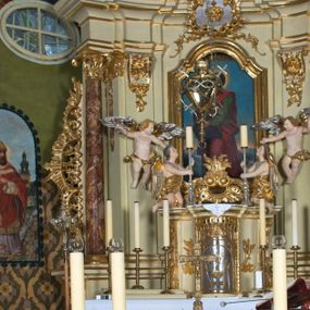 Zdjęcie nr 1: Malowidło w kształcie stojącego prostokąta zakończonego półkolistym łukiem, z bordiurą w formie granatowego ornamentu. Całopostaciowe frontalne przedstawienie św. Stanisława w stroju biskupim i nimbem wokół głowy. Twarz świętego pociągła, okolona ciemnym zarostem. Na głowie złota infuła, lewa ręka na piersiach, a w prawej pastorał. Biskup odziany w albę, spod której widoczny lewy trzewik, jasną dalmatykę ze złoconym galonem, czerwony ornat ze złotą lamówką oraz paliusz.

W prawym dolnym rogu półpostaciowa sylwetka Piotrowina zwróconego profilem w prawo. Twarz wydłużona, jasna karnacja, wydatny nos, siwe włosy i zarost. Postać ubrana w białą szatę, z białą chustą na głowie, lewą ręką wykonuje gest przemówienia.

W tle, po lewej stronie biskupa przedstawiono Wieżę Zegarową katedry wawelskiej oraz fragment budynku kapitularza, zaś u stóp świętego skałę porośniętą drobną roślinnością. 