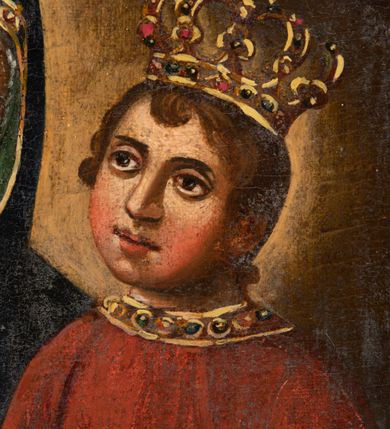 Zdjęcie nr 5: Pole obrazowe feretronu uzyskało kształt nieregularny. Ujmuje je rzeźbiona, wklęsło-wypukła profilowana rama, otoczona spływami wolutowymi oraz motywami rocaille. Niski, fazowany postument, do którego przymocowano górną część feretronu, przepruto dwoma kwadratowymi otworami umożliwiającymi włożenie drążków do noszenia. Na awersie feretronu w polu obrazowym przedstawiono Matkę Boską z Dzieciątkiem. Maria została ukazana frontalnie, w półpostaci. Na lewym ramieniu trzyma Dzieciątko, któremu prawą ręką podaje jabłko. Madonna ma jasną karnację z rumianymi policzkami. Jej twarz charakteryzuje wydatny, prosty nos, duże, ciemne oczy oraz wyraziste usta. Na głowie ma ciemnogranatowy maforion podbity zielenią, lamowany złotą taśmą dekorowaną naśladownictwem kameryzacji. Spod maforionu wokół głowy widać białą chustę. Maforion jest spięty pod szyją złotą fibulą w kształcie stylizowanego kwiatu. Okrywa on ramiona Marii odsłaniając jednocześnie na piersi i pod prawą ręką fragmenty fioletowej sukni spodniej, także lamowanej złotą taśmą z imitacją kameryzacji. Na prawym ramieniu maforion ozdobiony jest złotą, ośmioramienną gwiazdą w otoku. Matka Boska ma na lekko pochylonej w lewo głowie złotą, zamkniętą koronę, zwieńczoną globem z krzyżykiem. Obręcz i pałąki korony zdobione są malowanymi kamieniami szlachetnymi. Siedzący na lewym ramieniu mały Jezus ujęty został w trzech czwartych. W lewej ręce trzyma kodeks Ewangelii, a prawą sięga po jabłko trzymane przez Matkę w prawej ręce. Dzieciątko o rumianych policzkach ma jasną karnację. Jego twarz jest owalna. Charakteryzują ją duże, ciemne oczy, wydatny nos i czerwone usta. Na głowie ma krótkie, brązowe włosy z charakterystycznymi lokami i kosmykiem wychylającym się spod korony na czole. Mały Jezus ubrany jest w lamowaną złotą taśmą z imitacją kameryzacji szkarłatną tunikę, przewiązaną taką samą taśmą w pasie. Spod niej widoczne są częściowo obie jego stopy obute w sandały. Jezus ma na głowie zamkniętą złotą koronę, zwieńczoną krzyżykiem. Zarówno obręcz, jak i pałąki dekorowane są malarską imitacją kameryzacji. Postacie zostały przedstawione na brązowym tle, rozjaśnionym świetlistymi nimbami widocznymi wokół głowy Madonny i Dzieciątka. Na rewersie feretronu przedstawiono św. Józefa z Dzieciątkiem na rękach. Józef został ukazany stojąc w dwóch trzecich postaci. Ujęty został w trzech czwartych w prawo. Jest to starszy mężczyzna z wyraźnie zwróconą głową w prawą stronę. Nad jego głową widać nieznacznie zaznaczony nimb talerzowy z gwiazdą w środku. Ma siwe włosy i taki sam krótki zarost. Jego twarz jest pociągła o śniadej karnacji z wydatnym nosem, ustami i szeroko otwartymi niebieskimi oczami. Ma na sobie ciemnoniebieską tunikę oraz osuwający się z ramion ciemnoochrowy płaszcz zakrywający zgięte w łokciach ręce, którymi podtrzymuje Dzieciątko. Mały Jezus został ujęty nago w trzech czwartych w lewo z wyraźnie zwróconą głową w tę samą stronę. Odchyla się od Józefa, trzymając w uniesionych rączkach drobne gałązki różanego krzewu. Ma jasną karnację. Jego twarz charakteryzuje wysokie czoło, częściowo zasłonięte przez krótkie, pofalowane włosy. Dzieciątko ma kształtnie malowany nos i usta oraz deltę nosową z lekko przymkniętymi oczami. Biodra Pana Jezusa okrywa biała chusta, odsłaniająca jego nóżki, spod której widać dłonie Józefa. Głowę małego Jezusa otacza świetlisty nimb.