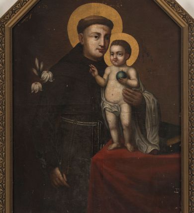 Zdjęcie nr 1: Pole obrazowe uzyskało formę stojącego prostokąta zamkniętego trójbocznie. Obraz ujmuje złocona i profilowana gipsowa rama z motywem roślinnym. Na wizerunku przedstawiono frontalnie stojącego św. Antoniego Padewskiego ukazanego w dwóch trzecich. Święty lewym ramieniem podtrzymuje stojące na stole Dzieciątko Jezus, a w prawej ręce ma kwiat lilii. Antoni został ujęty w trzech czwartych w lewo. Ma jasną karnację, długi pełny nos, duże oczy i wydatne usta. Na głowie widoczna jest tonsura wycięta w brązowych, krótkich włosach. Ubrany jest w brązowy habit franciszkański, przewiązany w pasie białym sznurem, przy którym wisi różaniec. Podtrzymywane nagie Dzieciątko Jezus stoi na stole przykrytym czerwoną tkaniną. Mały Jezus został ujęty w trzech czwartych w prawo. Prawą dłoń unosi w geście błogosławieństwa, w lewej natomiast trzyma niewielki niebieski glob ze złotym krzyżykiem. Ciało Zbawiciela ma jasną karnację. Twarz jest okrągła o różowych, pucułowatych policzkach. Jezus ma prosty nos, wydatne usta oraz szeroko otwarte ciemne oczy. Jego głowę otaczają krótkie, jasnobrązowe, kędzierzawe włosy. Fragment prawego biodra zasłania biała chusta opadająca z ramion małego Jezusa na lewą rękę św. Antoniego. Głowy obu postaci otaczają złote nimby. Obok Dzieciątka na stole leżą ułożone jedna na drugą dwie zamknięte księgi w ciemnych, jednolitych oprawach.
