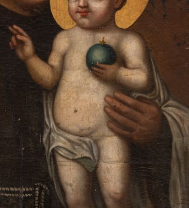 Zdjęcie nr 3: Pole obrazowe uzyskało formę stojącego prostokąta zamkniętego trójbocznie. Obraz ujmuje złocona i profilowana gipsowa rama z motywem roślinnym. Na wizerunku przedstawiono frontalnie stojącego św. Antoniego Padewskiego ukazanego w dwóch trzecich. Święty lewym ramieniem podtrzymuje stojące na stole Dzieciątko Jezus, a w prawej ręce ma kwiat lilii. Antoni został ujęty w trzech czwartych w lewo. Ma jasną karnację, długi pełny nos, duże oczy i wydatne usta. Na głowie widoczna jest tonsura wycięta w brązowych, krótkich włosach. Ubrany jest w brązowy habit franciszkański, przewiązany w pasie białym sznurem, przy którym wisi różaniec. Podtrzymywane nagie Dzieciątko Jezus stoi na stole przykrytym czerwoną tkaniną. Mały Jezus został ujęty w trzech czwartych w prawo. Prawą dłoń unosi w geście błogosławieństwa, w lewej natomiast trzyma niewielki niebieski glob ze złotym krzyżykiem. Ciało Zbawiciela ma jasną karnację. Twarz jest okrągła o różowych, pucułowatych policzkach. Jezus ma prosty nos, wydatne usta oraz szeroko otwarte ciemne oczy. Jego głowę otaczają krótkie, jasnobrązowe, kędzierzawe włosy. Fragment prawego biodra zasłania biała chusta opadająca z ramion małego Jezusa na lewą rękę św. Antoniego. Głowy obu postaci otaczają złote nimby. Obok Dzieciątka na stole leżą ułożone jedna na drugą dwie zamknięte księgi w ciemnych, jednolitych oprawach.
