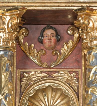 Zdjęcie nr 3: Ołtarz główny w Głębowicach otrzymał strukturę przyściennego, trójosiowego retabulum architektonicznego o dwóch kondygnacjach. Zaopatrzono go w predellę i zwieńczenie oraz dwa uszaki z boku zdobione herbem Starykoń i Jelita. Wisząc na ścianie wspiera się na dwóch masywnych, krótkich półkolumnach flankujących wejście do zakrystii. W środkowej części predelli widoczne jest wycięcie. Predellę po bokach ujmuje para konsoli wspierających wyłamujący się ponad nimi gzyms. Osie części środkowej nastawy ujęte są parami wolnostojących kolumn o kapitelach korynckich wspierających wyłamujące się ponad nimi belkowanie. Pole części środkowej nastawy ma kształt stojącego prostokąta zamkniętego nadwieszonym łukiem odcinkowym. Z kolei pola osi bocznych są artykułowane parą zamkniętych półkoliście niszy. Druga kondygnacja retabulum, będąca zarazem jego zwieńczeniem, została ujęta parą herm wspierających belkowanie przybierające formę łuku trójbocznego z ośmioboku. Po bokach widoczna jest para półkolistych, przerwanych przyczółków. Boki predelli ujęte zostały ulistnionymi wolutami, dodatkowo zdobionymi stylizowanymi motywami roślinno-kwiatowymi oraz motywem zwisu tkaniny z supłem. Konsole zdobione są liśćmi akantu oraz parą uskrzydlonych główek anielskich ze zwisami w formie pojedynczych kampanull. Po bokach predelli, na przedłużeniu zewnętrznych kolumn nastawy, podwieszono parę szyszek. Trzony kolumn zostały ozdobione w dolnej partii płaskorzeźbionymi, uskrzydlonymi główkami anielskimi, w górnej zewnętrzne – wicią winnej latorośli, zaś wewnętrzne motywem kandelabru. Osi boczne nastawy zostały ozdobione w dolnej partii ornamnetyką roślinną i parą główek anielskich ujętych motywami roślinnymi. Nisze dolnej kondygnacji wypełniono konchami, zdobionymi motywem ulistnionych rozetek. Z kolei trójboczne z ośmioboku konsole zostały ozdobione stylizowanymi liśćmi. W partii fryzu widoczna jest para mniejszych i większych uskrzydlonych główek anielskich. Drugą kondygnację - zwieńczenie, zostało ujęte parą herm z sylwetkami kobiecymi oraz parą uszaków o fantazyjnym wykroju z motywem maski lunarnej. Także fantazyjną formę z motywem głowy gryfa trzymającego w dziobie szarfę uzyskały uszaki w dolnej kondygnacji. W ich centrum widoczne są dwa owalne medaliony z herbem Starykoń i Jelita. W części środkowej nastawy znajduje się obraz Franciszka Lekszyckiego "Matka Boska Szkaplerzna wręcza szkaplerz św. Szymonowi Stockowi". Na zasuwie obraz "Matka Boska Różańcowa". Po bokach obrazu w niszach flankowanych kolumnami ustawiono rzeźbione wyobrażenie św. Marii Magdaleny i św. Katarzyny Aleksandryjskiej. W centrum drugiej kondygnacji-zwieńczeniu znajduje się obraz "Św. Maria Magdalena przed Ukrzyżowanym Chrystusem". Po bokach, na przyczółkach znajduje się para rzeźbionych stojących aniołów trzymających w dłoniach kartusze o fantazyjnych wykrojach. W kartuszu z prawej strony widnieje napis: "konserwacja 1973, 2016", a z lewej: "sancta scapularis". Na szczycie ołtarza trzy rzeźbione przedstawienia - bo bokach św. Piotra i św. Jana Ewangelisty, a po środku św. Krzysztofa. Struktura nastawy jest marmoryzowana w odcieniach różu i ceglastej czerwieni. Partie detalu architektonicznego i ornamentyka są złocone i srebrzone.