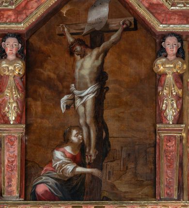 Zdjęcie nr 4: Obraz z przedstawieniem św. Marii Magdaleny klęczącej u stóp ukrzyżowanego Chrystusa uzyskał kształt stojącego prostokąta zamkniętego u góry trójbocznie. Krzyż na którym wisi Chrystus został zwrócony w trzech czwartych w prawo. Postać ukrzyżowanego Jezusa została przedstawiona w typie „Cristo morte”. Wyróżnia ją muskularnie modelowanie sylwetki. Pochyloną, wspartą na klatce piersiowej głowę okala ciemnobrązowy zarost i włosy opadające na plecy i kilkoma puklami po lewej stronie twarzy. Na jego głowie nałożona jest cierniowa korona. Ramiona Chrystusa uzyskały głęboki zwis w kształcie litery „V”.  Na biodrach widoczne jest krótkie, białe perizonium o rozwianym festonie na prawym boku, dodatkowo przewiązane sznurem. Wyprostowane nogi zostały przybite dwoma gwoźdźmi. Podobnie dwoma gwoździami przybito do szczytu krzyża duży, biały titulus z łacińskim napisem „REX JVDAEORVM”. Poniżej stóp Chrystusa dolną część krzyż obejmuje przyklękająca z prawej strony św. Maria Magdalena. Charakteryzuje ją jasna karnacja, zaokrąglona twarz o pełnych, młodzieńczych rysach, zapłakane oczy oraz długie, opadające na plecy włosy. Ubrana jest w długą, czerwoną suknię z szerokimi, białymi, podciągniętymi rękawami oraz osłaniający biodra szarobłękitny płaszcz. W tle, po prawej stronie krzyża szkicowo zaznaczony został pejzaż miejski. Ponad nim widoczne jest niebo przesłonięte chmurami w odcieniach brązu.