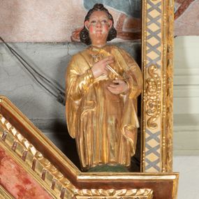 Zdjęcie nr 1: Święty Piotr został przedstawiony w całej postaci frontalnie. Ma owalną, szeroką twarz o sumarycznym modelunku rysów i wyraźnie rumianych policzkach. Jego ciemnobrązowe włosy sięgające szyi są założone za wydatne uszy. Święty ubrany jest w długą, złoconą przewiązaną w pasie tunikę oraz złocony płaszcz. W uniesionych na wysokości klatki piersiowej rękach trzyma dwa klucze, złoty i srebrny. 