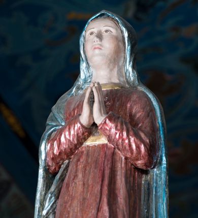 Zdjęcie nr 4: Grupa Ukrzyżowania składa się z pełnoplastycznych, całopostaciowych figur ustawionych na belce tęczowej. Pośrodku zamocowano polichromowany na ciemnobrązowo krzyż z realistycznie rzeźbioną figurą Chrystusa o plastycznie opracowanym modelunku muskulatury ciała. Postać do krzyża przytwierdzono za pomocą trzech gwoździ. Zbawiciel ma głowę pochyloną i złożoną na prawym barku. Posiada szeroką, owalną twarz o sumarycznie opracowanych rysach, półprzymknięte oczy, lekko rozchylone usta i krótki, ciemnobrązowy zarost. Długie, ciemnobrązowe, falowane włosy opadają mu na plecy i na prawy bark. Na głowie znajduje się zielona, cierniowa korona, spod której ciekną stróżki krwi. Nieproporcjonalnie długie ramiona ułożone zostały w płytkim, U-kształtnym zwisie z zaznaczonymi ścięgnami i żyłami na przedramionach. Dłonie o zaciśniętych palcach przybito dwoma gwoździami, spod których ciekną strużki krwi. Klatkę piersiową ukształtowano z wyraziście zaznaczoną linią żeber i raną w boku ze strugami krwi. Na biodrach umiejscowiono krótkie, złocone perizonium z festonem przy prawym boku. Jego zwichrowane draperie zostały ułożone horyzontalnie. Chrystus ma zgięte w kolanach nogi z założoną prawą stopą na lewą przybite jednym gwoździem. W górnej partii pionowej belki krzyża zawieszono biały titulus w formie banderoli z napisem: "INRI". 
U stóp krzyża, po lewej stronie, na niskiej, prostopadłościennej podstawie, ustawiono rzeźbę klęczącej św. Marii Magdaleny. Święta jest zwrócona profilem w prawo. Jej owalną twarz charakteryzują sumarycznie opracowane rysy. Ma długie brązowe, lekko falowane włosy opadające na plecy. Ubrana jest w długą, srebrzystobłękitną, drobno fałdowaną suknię związaną srebrnym paskiem. Oburącz ujmuje pionową belkę krzyża. Tuż obok niej, na lewo, na niskiej, prostopadłościennej podstawie ustawiono figurę stojącej frontalnie Matki Boskiej Bolesnej. Jej nieznacznie odchyloną głowę charakteryzuje owalna, szeroka twarz o sumarycznie opracowanych rysach i wzroku skierowanym ku górze. Maria ubrana jest w długą srebrzyścieczerwoną suknię przewiązaną złotym paskiem i osłaniający głowę, plecy i prawe ramię, drobnofałdowany srebrzysty płaszcz. Ręce trzyma złożone w geście modlitwy. Po prawej stronie krzyża na niskiej, prostopadłościennej podstawie zamocowano stojącą figurę św. Jana Ewangelisty, ujętego frontalnie w nieznacznym kontrapoście. Święty ma lekko odchyloną do tyłu, zwróconą w trzech czwartych w lewo głowę. Charakteryzuje ją owalna, szeroka twarz o sumarycznie opracowanych rysach. Na plecy opadają mu długie, falowane, brązowe włosy. Jan ubrany jest w długą, srebrzystozieloną tunikę i przerzucony przez prawe ramię i podtrzymywany lewym przedramieniem złocistoochrowy płaszcz. Ręce trzyma skrzyżowane na piersiach. Z tyłu titulusa widnieje napis: Malował Jan i Ludwik, bracia Stankiewicze 1913. Napis widoczny jest także na górnej płaszczyźnie z tyłu krzyża: Malował 1913. 
Belka tęczowa jest prostopadłościenna, o profilowanych dolnych narożach. Polichromowano ją w odcieniach zieleni, czerwieni i żółci. Na środku widnieje flankowany parą złoconych krzyżyków złocony z przodu napis: + OTO BARANEK BOŻY KTÓRY GŁADZI GRZECHY ŚWIATA +; z tyłu: RENOVATUM A[nno] D[omini] 1913 + 1953 + 1983 + 2013