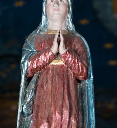 Zdjęcie nr 3: Grupa Ukrzyżowania składa się z pełnoplastycznych, całopostaciowych figur ustawionych na belce tęczowej. Pośrodku zamocowano polichromowany na ciemnobrązowo krzyż z realistycznie rzeźbioną figurą Chrystusa o plastycznie opracowanym modelunku muskulatury ciała. Postać do krzyża przytwierdzono za pomocą trzech gwoździ. Zbawiciel ma głowę pochyloną i złożoną na prawym barku. Posiada szeroką, owalną twarz o sumarycznie opracowanych rysach, półprzymknięte oczy, lekko rozchylone usta i krótki, ciemnobrązowy zarost. Długie, ciemnobrązowe, falowane włosy opadają mu na plecy i na prawy bark. Na głowie znajduje się zielona, cierniowa korona, spod której ciekną stróżki krwi. Nieproporcjonalnie długie ramiona ułożone zostały w płytkim, U-kształtnym zwisie z zaznaczonymi ścięgnami i żyłami na przedramionach. Dłonie o zaciśniętych palcach przybito dwoma gwoździami, spod których ciekną strużki krwi. Klatkę piersiową ukształtowano z wyraziście zaznaczoną linią żeber i raną w boku ze strugami krwi. Na biodrach umiejscowiono krótkie, złocone perizonium z festonem przy prawym boku. Jego zwichrowane draperie zostały ułożone horyzontalnie. Chrystus ma zgięte w kolanach nogi z założoną prawą stopą na lewą przybite jednym gwoździem. W górnej partii pionowej belki krzyża zawieszono biały titulus w formie banderoli z napisem: "INRI". 
U stóp krzyża, po lewej stronie, na niskiej, prostopadłościennej podstawie, ustawiono rzeźbę klęczącej św. Marii Magdaleny. Święta jest zwrócona profilem w prawo. Jej owalną twarz charakteryzują sumarycznie opracowane rysy. Ma długie brązowe, lekko falowane włosy opadające na plecy. Ubrana jest w długą, srebrzystobłękitną, drobno fałdowaną suknię związaną srebrnym paskiem. Oburącz ujmuje pionową belkę krzyża. Tuż obok niej, na lewo, na niskiej, prostopadłościennej podstawie ustawiono figurę stojącej frontalnie Matki Boskiej Bolesnej. Jej nieznacznie odchyloną głowę charakteryzuje owalna, szeroka twarz o sumarycznie opracowanych rysach i wzroku skierowanym ku górze. Maria ubrana jest w długą srebrzyścieczerwoną suknię przewiązaną złotym paskiem i osłaniający głowę, plecy i prawe ramię, drobnofałdowany srebrzysty płaszcz. Ręce trzyma złożone w geście modlitwy. Po prawej stronie krzyża na niskiej, prostopadłościennej podstawie zamocowano stojącą figurę św. Jana Ewangelisty, ujętego frontalnie w nieznacznym kontrapoście. Święty ma lekko odchyloną do tyłu, zwróconą w trzech czwartych w lewo głowę. Charakteryzuje ją owalna, szeroka twarz o sumarycznie opracowanych rysach. Na plecy opadają mu długie, falowane, brązowe włosy. Jan ubrany jest w długą, srebrzystozieloną tunikę i przerzucony przez prawe ramię i podtrzymywany lewym przedramieniem złocistoochrowy płaszcz. Ręce trzyma skrzyżowane na piersiach. Z tyłu titulusa widnieje napis: Malował Jan i Ludwik, bracia Stankiewicze 1913. Napis widoczny jest także na górnej płaszczyźnie z tyłu krzyża: Malował 1913. 
Belka tęczowa jest prostopadłościenna, o profilowanych dolnych narożach. Polichromowano ją w odcieniach zieleni, czerwieni i żółci. Na środku widnieje flankowany parą złoconych krzyżyków złocony z przodu napis: + OTO BARANEK BOŻY KTÓRY GŁADZI GRZECHY ŚWIATA +; z tyłu: RENOVATUM A[nno] D[omini] 1913 + 1953 + 1983 + 2013