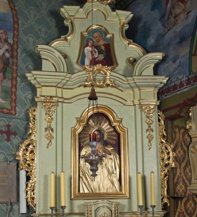 Zdjęcie nr 1: Ołtarz architektoniczny, jednokondygnacyjny, jednoosiowy ze zwieńczeniem. Ołtarz prostopadłościenny, z drewnianą mensą i antepedium w formie płyciny w kształcie leżącego prostokąta. Retabulum na zdwojonym, uskokowym cokole. Dolna partia cokołu, ujmująca z obydwu stron ołtarz, lekko wypukła, górna o podwójnie zryzalitowanych bokach. Część środkowa retabulum ujęta parą zdwojonych pilastrów wspierających lekko wyłamujące się nad nimi belkowanie, w części środkowej w formie odcinkowego łuku nadwieszonego. Zwieńczenie ujęte parą spływów wolutowych wspierających wyłamujący się ponad nimi gzyms w formie półkolistego łuku nadwieszonego. Po bokach zwieńczenia przerwany, półkolisty przyczółek w układzie lustrzanego odbicia. Środkowa część retabulum ujęta parą ażurowych, rocaille'owych uszaków z rozetkami. W górnej partii pilastrów ornament w formie rocaille'owych zwisów z gałązkami z rozetkami. W kluczu łuku belkowania ażurowy, rocaille'owy kartusz. Szczyt zwieńczenia w formie rocaille'owego kartusza z monogramem IHS na ciemnoczerwonym tle. Pole części środkowej retabulum w kształcie stojącego prostokąta zamkniętego uskokowym, półkolistym łukiem nadwieszonym, ujęte profilowaną, złoconą ramą. W środku obraz Najświętsze Serce Jezusa. Na zasuwie obraz ze św. Florianem.  Pole zwieńczenia o lekko wklęsłych bokach i podstawie oraz ściętych dolnych narożach, zamknięte półkolistym łukiem nadwieszonym, ujęte profilowaną, złoconą ramą. W środku obraz Matki Boskiej nauczającej Jezusa.

 Struktura ołtarza polichromowana w pastelowym odcieniu szarozielonym, partie detalu architektonicznego i ornamentyka złocone.

 Na mensie ołtarza znajduje się tabernakulum w kształcie prostopadłościennej szafki o uskokowych bokach i wypukłej części środkowej, zwieńczone wyłamującym się gzymsem w części środkowej w formie łuku odcinkowego. Wnętrze tabernakulum jest obrotowe. Struktura ozdobiona motywami ciągów liści laurowych i trójliści, w środku monogram IHS dołem ujęty skrzyżowaną parą gałązek palmowych z rozetką pośrodku. Struktura polichromowana w pastelowym odcieniu szarozielonym, partie detalu i ornamentyka złocone.