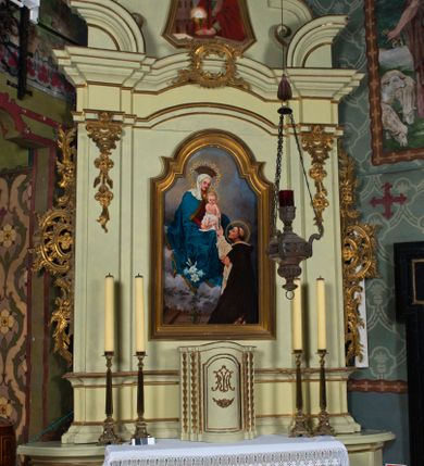 Zdjęcie nr 2: Ołtarz architektoniczny, jednokondygnacyjny, jednoosiowy ze zwieńczeniem. Ołtarz prostopadłościenny, z drewnianą mensą i antepedium w formie płyciny w kształcie leżącego prostokąta. Retabulum na zdwojonym, uskokowym cokole. Dolna partia cokołu, ujmująca z obydwu stron ołtarz, lekko wypukła, górna o podwójnie zryzalitowanych bokach. Część środkowa retabulum ujęta parą zdwojonych pilastrów wspierających lekko wyłamujące się nad nimi belkowanie, w części środkowej w formie odcinkowego łuku nadwieszonego. Zwieńczenie ujęte parą spływów wolutowych wspierających wyłamujący się ponad nimi gzyms w formie półkolistego łuku nadwieszonego. Po bokach zwieńczenia przerwany, półkolisty przyczółek w układzie lustrzanego odbicia. Środkowa część retabulum ujęta parą ażurowych, rocaille'owych uszaków z rozetkami. W górnej partii pilastrów ornament w formie rocaille'owych zwisów z gałązkami z rozetkami. W kluczu łuku belkowania ażurowy, rocaille'owy kartusz. Szczyt zwieńczenia w formie rocaille'owego kartusza z monogramem maryjnym na ciemnoczerwonym tle. W polu części środkowej retabulum wnęka w kształcie stojącego prostokąta zamkniętego uskokowym, półkolistym łukiem nadwieszonym, ujęta profilowaną, złoconą ramą. Ścianki wnęki w kolorze błękitnym. W środku figura Matki Boskiej Fatimskiej. Na zasuwie obraz Matki Boskiej Różańcowej.  Pole zwieńczenia o lekko wklęsłych bokach i podstawie oraz ściętych dolnych narożach, zamknięte półkolistym łukiem nadwieszonym, ujęte profilowaną, złoconą ramą. W środku obraz św. Barbary.

 Struktura ołtarza polichromowana w pastelowym odcieniu szarozielonym, partie detalu architektonicznego i ornamentyka złocone.

 Na mensie ołtarza tabernakulum w kształcie prostopadłościennej szafki o uskokowych bokach i wypukłej części środkowej, zwieńczone wyłamującym się gzymsem w części środkowej w formie łuku odcinkowego. Wnętrze tabernakulum obrotowe. Struktura ozdobiona motywami ciągów liści laurowych i trójliści, w środku monogram maryjny dołem ujęty skrzyżowaną parą gałązek palmowych z rozetką pośrodku. Struktura polichromowana w pastelowym odcieniu szarozielonym, partie detalu i ornamentyka złocone.