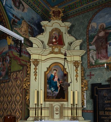 Zdjęcie nr 1: Ołtarz architektoniczny, jednokondygnacyjny, jednoosiowy ze zwieńczeniem. Ołtarz prostopadłościenny, z drewnianą mensą i antepedium w formie płyciny w kształcie leżącego prostokąta. Retabulum na zdwojonym, uskokowym cokole. Dolna partia cokołu, ujmująca z obydwu stron ołtarz, lekko wypukła, górna o podwójnie zryzalitowanych bokach. Część środkowa retabulum ujęta parą zdwojonych pilastrów wspierających lekko wyłamujące się nad nimi belkowanie, w części środkowej w formie odcinkowego łuku nadwieszonego. Zwieńczenie ujęte parą spływów wolutowych wspierających wyłamujący się ponad nimi gzyms w formie półkolistego łuku nadwieszonego. Po bokach zwieńczenia przerwany, półkolisty przyczółek w układzie lustrzanego odbicia. Środkowa część retabulum ujęta parą ażurowych, rocaille'owych uszaków z rozetkami. W górnej partii pilastrów ornament w formie rocaille'owych zwisów z gałązkami z rozetkami. W kluczu łuku belkowania ażurowy, rocaille'owy kartusz. Szczyt zwieńczenia w formie rocaille'owego kartusza z monogramem maryjnym na ciemnoczerwonym tle. W polu części środkowej retabulum wnęka w kształcie stojącego prostokąta zamkniętego uskokowym, półkolistym łukiem nadwieszonym, ujęta profilowaną, złoconą ramą. Ścianki wnęki w kolorze błękitnym. W środku figura Matki Boskiej Fatimskiej. Na zasuwie obraz Matki Boskiej Różańcowej.  Pole zwieńczenia o lekko wklęsłych bokach i podstawie oraz ściętych dolnych narożach, zamknięte półkolistym łukiem nadwieszonym, ujęte profilowaną, złoconą ramą. W środku obraz św. Barbary.

 Struktura ołtarza polichromowana w pastelowym odcieniu szarozielonym, partie detalu architektonicznego i ornamentyka złocone.

 Na mensie ołtarza tabernakulum w kształcie prostopadłościennej szafki o uskokowych bokach i wypukłej części środkowej, zwieńczone wyłamującym się gzymsem w części środkowej w formie łuku odcinkowego. Wnętrze tabernakulum obrotowe. Struktura ozdobiona motywami ciągów liści laurowych i trójliści, w środku monogram maryjny dołem ujęty skrzyżowaną parą gałązek palmowych z rozetką pośrodku. Struktura polichromowana w pastelowym odcieniu szarozielonym, partie detalu i ornamentyka złocone.