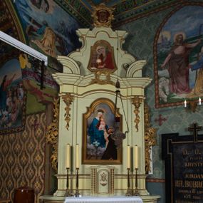 Zdjęcie nr 1: Ołtarz architektoniczny, jednokondygnacyjny, jednoosiowy ze zwieńczeniem. Ołtarz prostopadłościenny, z drewnianą mensą i antepedium w formie płyciny w kształcie leżącego prostokąta. Retabulum na zdwojonym, uskokowym cokole. Dolna partia cokołu, ujmująca z obydwu stron ołtarz, lekko wypukła, górna o podwójnie zryzalitowanych bokach. Część środkowa retabulum ujęta parą zdwojonych pilastrów wspierających lekko wyłamujące się nad nimi belkowanie, w części środkowej w formie odcinkowego łuku nadwieszonego. Zwieńczenie ujęte parą spływów wolutowych wspierających wyłamujący się ponad nimi gzyms w formie półkolistego łuku nadwieszonego. Po bokach zwieńczenia przerwany, półkolisty przyczółek w układzie lustrzanego odbicia. Środkowa część retabulum ujęta parą ażurowych, rocaille'owych uszaków z rozetkami. W górnej partii pilastrów ornament w formie rocaille'owych zwisów z gałązkami z rozetkami. W kluczu łuku belkowania ażurowy, rocaille'owy kartusz. Szczyt zwieńczenia w formie rocaille'owego kartusza z monogramem maryjnym na ciemnoczerwonym tle. W polu części środkowej retabulum wnęka w kształcie stojącego prostokąta zamkniętego uskokowym, półkolistym łukiem nadwieszonym, ujęta profilowaną, złoconą ramą. Ścianki wnęki w kolorze błękitnym. W środku figura Matki Boskiej Fatimskiej. Na zasuwie obraz Matki Boskiej Różańcowej.  Pole zwieńczenia o lekko wklęsłych bokach i podstawie oraz ściętych dolnych narożach, zamknięte półkolistym łukiem nadwieszonym, ujęte profilowaną, złoconą ramą. W środku obraz św. Barbary.

 Struktura ołtarza polichromowana w pastelowym odcieniu szarozielonym, partie detalu architektonicznego i ornamentyka złocone.

 Na mensie ołtarza tabernakulum w kształcie prostopadłościennej szafki o uskokowych bokach i wypukłej części środkowej, zwieńczone wyłamującym się gzymsem w części środkowej w formie łuku odcinkowego. Wnętrze tabernakulum obrotowe. Struktura ozdobiona motywami ciągów liści laurowych i trójliści, w środku monogram maryjny dołem ujęty skrzyżowaną parą gałązek palmowych z rozetką pośrodku. Struktura polichromowana w pastelowym odcieniu szarozielonym, partie detalu i ornamentyka złocone.