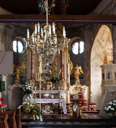 Zdjęcie nr 82: Kościół orientowany, murowany, jednonawowy z węższym prezbiterium zakończonym półkolistą absydą. Przy prezbiterium od północy znajduje się zakrystia, od południa kwadratowa kaplica św. Anny, a przy nawie od południa kruchta. Wnętrze kościoła nakryte jest nowym stropem, natomiast w kaplicy znajduje się sklepienie krzyżowo-żebrowe. Fasada zachodnia ujęta jest na narożnikach skośnymi szkarpami i zwieńczona schodkowym szczytem, podobnie zwieńczona jest kruchta południowa. Portal zachodni kamienny, z belkowaniem wspartym na dwóch liściastych konsolach ponad którymi edikula z płaskorzeźbionym krucyfiksem i klęczącymi postaciami męskimi. Na belkowaniu znajdują się dwa kartusze z herbami: po lewej herb Bończa, a nad nim litery „I” oraz „T”, a na prawo herb Szreniawa i litery „B” i „T”. Portal kruchty południowej jest również kamienny, podobny do zachodniego z inskrypcją: „IN LAVDEM ET GL[ORI]AM DEI O[MN]IP[OTENTIS] HO[NO]RE[M] / B(EATE) M(ARIAE) S(ANCTAE) V(IRGINIS) S(ANCTUS) AEGIDY ET OM(NIUM) SS. FIR. REGNÃTE [TERTIO] SIGISM[UN]DO / REGE POL[ONIAE] Z[?] HEMO[?] EP[ISCOP]O CRAC(OVIENSIS) BERN[AR]DO MACIEIOWSKI / NOVIT[ER] CAR[DINA]LI CRA[COVIENSE] DEI FACTO INTERI[M] PLEBA[N]O R[E]V[EREN]DO SEB(ASTIANO) / NAGRODIO A I SYRADIA PHI[LOSOPHI]AE DOCTORE COLLEG[I]A [MA]IORE / S. T(HEOLOGIAE) PVBLICO PROFES(SORE) PRAEP[OSI]TO S(ANCTA) AN(NAE) CRAC[OVIAE] DECIMARVM / ET FVNDI ECCL(ESIA)E HVIVS P[OST] IVRIS STREPITV(M) RESTITV / TORE ANNO OCTAVO PLEBANAT[U]S SVI. TEMPLVM HO(C) / [ dwa wiersze skute] DE' / NOWO AEDIFICATVM. ET. CONSTRVCTVM. ADIVTORIO / QVORVNDÃ ANNO D[OMINI] MDCIIII MENSE SEPTEMB[RE]”. Od południa świątyni umieszczone są trzy otwory okienne w kształcie stojących prostokątów, zamkniętych łukiem półkolistym, a w prezbiterium dwa małe okrągłe okna. Kościół nakryty jest dwoma dwuspadowymi dachami, nad prezbiterium nieco niższym, nad nawą zwieńczonym wąską i wysoką sygnaturką na dzwon. Wewnątrz świątyni na skrzyżowaniu nawy i prezbiterium umocowana jest drewniana belka tęczowa z ustawionym na niej krucyfiksem i figurami Matki Boskiej i św. Jana Ewangelisty. Chór zachodni drewniany, na planie prostokąta, pośrodku półkoliście zamknięty, wsparty na sześciu filarach, od północnego zachodu z obudowaną boazerią klatką schodową. 