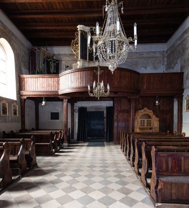 Zdjęcie nr 86: Kościół orientowany, murowany, jednonawowy z węższym prezbiterium zakończonym półkolistą absydą. Przy prezbiterium od północy znajduje się zakrystia, od południa kwadratowa kaplica św. Anny, a przy nawie od południa kruchta. Wnętrze kościoła nakryte jest nowym stropem, natomiast w kaplicy znajduje się sklepienie krzyżowo-żebrowe. Fasada zachodnia ujęta jest na narożnikach skośnymi szkarpami i zwieńczona schodkowym szczytem, podobnie zwieńczona jest kruchta południowa. Portal zachodni kamienny, z belkowaniem wspartym na dwóch liściastych konsolach ponad którymi edikula z płaskorzeźbionym krucyfiksem i klęczącymi postaciami męskimi. Na belkowaniu znajdują się dwa kartusze z herbami: po lewej herb Bończa, a nad nim litery „I” oraz „T”, a na prawo herb Szreniawa i litery „B” i „T”. Portal kruchty południowej jest również kamienny, podobny do zachodniego z inskrypcją: „IN LAVDEM ET GL[ORI]AM DEI O[MN]IP[OTENTIS] HO[NO]RE[M] / B(EATE) M(ARIAE) S(ANCTAE) V(IRGINIS) S(ANCTUS) AEGIDY ET OM(NIUM) SS. FIR. REGNÃTE [TERTIO] SIGISM[UN]DO / REGE POL[ONIAE] Z[?] HEMO[?] EP[ISCOP]O CRAC(OVIENSIS) BERN[AR]DO MACIEIOWSKI / NOVIT[ER] CAR[DINA]LI CRA[COVIENSE] DEI FACTO INTERI[M] PLEBA[N]O R[E]V[EREN]DO SEB(ASTIANO) / NAGRODIO A I SYRADIA PHI[LOSOPHI]AE DOCTORE COLLEG[I]A [MA]IORE / S. T(HEOLOGIAE) PVBLICO PROFES(SORE) PRAEP[OSI]TO S(ANCTA) AN(NAE) CRAC[OVIAE] DECIMARVM / ET FVNDI ECCL(ESIA)E HVIVS P[OST] IVRIS STREPITV(M) RESTITV / TORE ANNO OCTAVO PLEBANAT[U]S SVI. TEMPLVM HO(C) / [ dwa wiersze skute] DE' / NOWO AEDIFICATVM. ET. CONSTRVCTVM. ADIVTORIO / QVORVNDÃ ANNO D[OMINI] MDCIIII MENSE SEPTEMB[RE]”. Od południa świątyni umieszczone są trzy otwory okienne w kształcie stojących prostokątów, zamkniętych łukiem półkolistym, a w prezbiterium dwa małe okrągłe okna. Kościół nakryty jest dwoma dwuspadowymi dachami, nad prezbiterium nieco niższym, nad nawą zwieńczonym wąską i wysoką sygnaturką na dzwon. Wewnątrz świątyni na skrzyżowaniu nawy i prezbiterium umocowana jest drewniana belka tęczowa z ustawionym na niej krucyfiksem i figurami Matki Boskiej i św. Jana Ewangelisty. Chór zachodni drewniany, na planie prostokąta, pośrodku półkoliście zamknięty, wsparty na sześciu filarach, od północnego zachodu z obudowaną boazerią klatką schodową. 