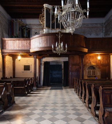 Zdjęcie nr 87: Kościół orientowany, murowany, jednonawowy z węższym prezbiterium zakończonym półkolistą absydą. Przy prezbiterium od północy znajduje się zakrystia, od południa kwadratowa kaplica św. Anny, a przy nawie od południa kruchta. Wnętrze kościoła nakryte jest nowym stropem, natomiast w kaplicy znajduje się sklepienie krzyżowo-żebrowe. Fasada zachodnia ujęta jest na narożnikach skośnymi szkarpami i zwieńczona schodkowym szczytem, podobnie zwieńczona jest kruchta południowa. Portal zachodni kamienny, z belkowaniem wspartym na dwóch liściastych konsolach ponad którymi edikula z płaskorzeźbionym krucyfiksem i klęczącymi postaciami męskimi. Na belkowaniu znajdują się dwa kartusze z herbami: po lewej herb Bończa, a nad nim litery „I” oraz „T”, a na prawo herb Szreniawa i litery „B” i „T”. Portal kruchty południowej jest również kamienny, podobny do zachodniego z inskrypcją: „IN LAVDEM ET GL[ORI]AM DEI O[MN]IP[OTENTIS] HO[NO]RE[M] / B(EATE) M(ARIAE) S(ANCTAE) V(IRGINIS) S(ANCTUS) AEGIDY ET OM(NIUM) SS. FIR. REGNÃTE [TERTIO] SIGISM[UN]DO / REGE POL[ONIAE] Z[?] HEMO[?] EP[ISCOP]O CRAC(OVIENSIS) BERN[AR]DO MACIEIOWSKI / NOVIT[ER] CAR[DINA]LI CRA[COVIENSE] DEI FACTO INTERI[M] PLEBA[N]O R[E]V[EREN]DO SEB(ASTIANO) / NAGRODIO A I SYRADIA PHI[LOSOPHI]AE DOCTORE COLLEG[I]A [MA]IORE / S. T(HEOLOGIAE) PVBLICO PROFES(SORE) PRAEP[OSI]TO S(ANCTA) AN(NAE) CRAC[OVIAE] DECIMARVM / ET FVNDI ECCL(ESIA)E HVIVS P[OST] IVRIS STREPITV(M) RESTITV / TORE ANNO OCTAVO PLEBANAT[U]S SVI. TEMPLVM HO(C) / [ dwa wiersze skute] DE' / NOWO AEDIFICATVM. ET. CONSTRVCTVM. ADIVTORIO / QVORVNDÃ ANNO D[OMINI] MDCIIII MENSE SEPTEMB[RE]”. Od południa świątyni umieszczone są trzy otwory okienne w kształcie stojących prostokątów, zamkniętych łukiem półkolistym, a w prezbiterium dwa małe okrągłe okna. Kościół nakryty jest dwoma dwuspadowymi dachami, nad prezbiterium nieco niższym, nad nawą zwieńczonym wąską i wysoką sygnaturką na dzwon. Wewnątrz świątyni na skrzyżowaniu nawy i prezbiterium umocowana jest drewniana belka tęczowa z ustawionym na niej krucyfiksem i figurami Matki Boskiej i św. Jana Ewangelisty. Chór zachodni drewniany, na planie prostokąta, pośrodku półkoliście zamknięty, wsparty na sześciu filarach, od północnego zachodu z obudowaną boazerią klatką schodową. 