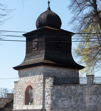 Zdjęcie nr 98: Kościół orientowany, murowany, jednonawowy z węższym prezbiterium zakończonym półkolistą absydą. Przy prezbiterium od północy znajduje się zakrystia, od południa kwadratowa kaplica św. Anny, a przy nawie od południa kruchta. Wnętrze kościoła nakryte jest nowym stropem, natomiast w kaplicy znajduje się sklepienie krzyżowo-żebrowe. Fasada zachodnia ujęta jest na narożnikach skośnymi szkarpami i zwieńczona schodkowym szczytem, podobnie zwieńczona jest kruchta południowa. Portal zachodni kamienny, z belkowaniem wspartym na dwóch liściastych konsolach ponad którymi edikula z płaskorzeźbionym krucyfiksem i klęczącymi postaciami męskimi. Na belkowaniu znajdują się dwa kartusze z herbami: po lewej herb Bończa, a nad nim litery „I” oraz „T”, a na prawo herb Szreniawa i litery „B” i „T”. Portal kruchty południowej jest również kamienny, podobny do zachodniego z inskrypcją: „IN LAVDEM ET GL[ORI]AM DEI O[MN]IP[OTENTIS] HO[NO]RE[M] / B(EATE) M(ARIAE) S(ANCTAE) V(IRGINIS) S(ANCTUS) AEGIDY ET OM(NIUM) SS. FIR. REGNÃTE [TERTIO] SIGISM[UN]DO / REGE POL[ONIAE] Z[?] HEMO[?] EP[ISCOP]O CRAC(OVIENSIS) BERN[AR]DO MACIEIOWSKI / NOVIT[ER] CAR[DINA]LI CRA[COVIENSE] DEI FACTO INTERI[M] PLEBA[N]O R[E]V[EREN]DO SEB(ASTIANO) / NAGRODIO A I SYRADIA PHI[LOSOPHI]AE DOCTORE COLLEG[I]A [MA]IORE / S. T(HEOLOGIAE) PVBLICO PROFES(SORE) PRAEP[OSI]TO S(ANCTA) AN(NAE) CRAC[OVIAE] DECIMARVM / ET FVNDI ECCL(ESIA)E HVIVS P[OST] IVRIS STREPITV(M) RESTITV / TORE ANNO OCTAVO PLEBANAT[U]S SVI. TEMPLVM HO(C) / [ dwa wiersze skute] DE' / NOWO AEDIFICATVM. ET. CONSTRVCTVM. ADIVTORIO / QVORVNDÃ ANNO D[OMINI] MDCIIII MENSE SEPTEMB[RE]”. Od południa świątyni umieszczone są trzy otwory okienne w kształcie stojących prostokątów, zamkniętych łukiem półkolistym, a w prezbiterium dwa małe okrągłe okna. Kościół nakryty jest dwoma dwuspadowymi dachami, nad prezbiterium nieco niższym, nad nawą zwieńczonym wąską i wysoką sygnaturką na dzwon. Wewnątrz świątyni na skrzyżowaniu nawy i prezbiterium umocowana jest drewniana belka tęczowa z ustawionym na niej krucyfiksem i figurami Matki Boskiej i św. Jana Ewangelisty. Chór zachodni drewniany, na planie prostokąta, pośrodku półkoliście zamknięty, wsparty na sześciu filarach, od północnego zachodu z obudowaną boazerią klatką schodową. 