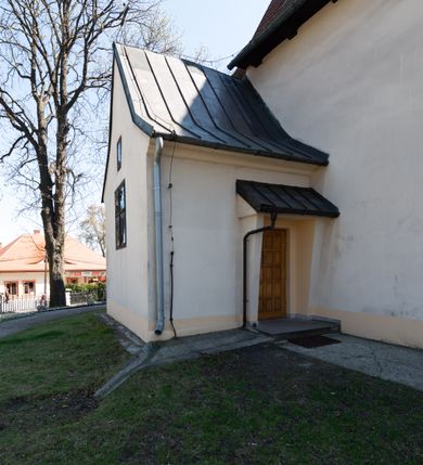 Zdjęcie nr 21: Kościół orientowany, murowany, jednonawowy z węższym prezbiterium zakończonym półkolistą absydą. Przy prezbiterium od północy znajduje się zakrystia, od południa kwadratowa kaplica św. Anny, a przy nawie od południa kruchta. Wnętrze kościoła nakryte jest nowym stropem, natomiast w kaplicy znajduje się sklepienie krzyżowo-żebrowe. Fasada zachodnia ujęta jest na narożnikach skośnymi szkarpami i zwieńczona schodkowym szczytem, podobnie zwieńczona jest kruchta południowa. Portal zachodni kamienny, z belkowaniem wspartym na dwóch liściastych konsolach ponad którymi edikula z płaskorzeźbionym krucyfiksem i klęczącymi postaciami męskimi. Na belkowaniu znajdują się dwa kartusze z herbami: po lewej herb Bończa, a nad nim litery „I” oraz „T”, a na prawo herb Szreniawa i litery „B” i „T”. Portal kruchty południowej jest również kamienny, podobny do zachodniego z inskrypcją: „IN LAVDEM ET GL[ORI]AM DEI O[MN]IP[OTENTIS] HO[NO]RE[M] / B(EATE) M(ARIAE) S(ANCTAE) V(IRGINIS) S(ANCTUS) AEGIDY ET OM(NIUM) SS. FIR. REGNÃTE [TERTIO] SIGISM[UN]DO / REGE POL[ONIAE] Z[?] HEMO[?] EP[ISCOP]O CRAC(OVIENSIS) BERN[AR]DO MACIEIOWSKI / NOVIT[ER] CAR[DINA]LI CRA[COVIENSE] DEI FACTO INTERI[M] PLEBA[N]O R[E]V[EREN]DO SEB(ASTIANO) / NAGRODIO A I SYRADIA PHI[LOSOPHI]AE DOCTORE COLLEG[I]A [MA]IORE / S. T(HEOLOGIAE) PVBLICO PROFES(SORE) PRAEP[OSI]TO S(ANCTA) AN(NAE) CRAC[OVIAE] DECIMARVM / ET FVNDI ECCL(ESIA)E HVIVS P[OST] IVRIS STREPITV(M) RESTITV / TORE ANNO OCTAVO PLEBANAT[U]S SVI. TEMPLVM HO(C) / [ dwa wiersze skute] DE' / NOWO AEDIFICATVM. ET. CONSTRVCTVM. ADIVTORIO / QVORVNDÃ ANNO D[OMINI] MDCIIII MENSE SEPTEMB[RE]”. Od południa świątyni umieszczone są trzy otwory okienne w kształcie stojących prostokątów, zamkniętych łukiem półkolistym, a w prezbiterium dwa małe okrągłe okna. Kościół nakryty jest dwoma dwuspadowymi dachami, nad prezbiterium nieco niższym, nad nawą zwieńczonym wąską i wysoką sygnaturką na dzwon. Wewnątrz świątyni na skrzyżowaniu nawy i prezbiterium umocowana jest drewniana belka tęczowa z ustawionym na niej krucyfiksem i figurami Matki Boskiej i św. Jana Ewangelisty. Chór zachodni drewniany, na planie prostokąta, pośrodku półkoliście zamknięty, wsparty na sześciu filarach, od północnego zachodu z obudowaną boazerią klatką schodową. 