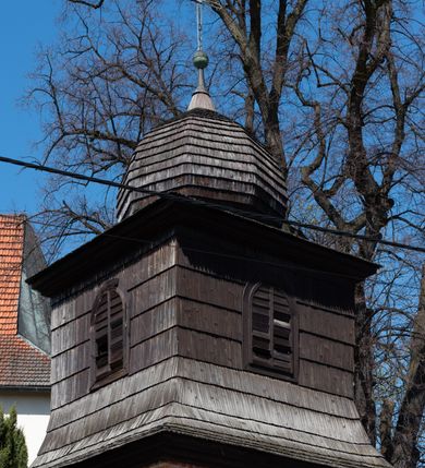 Zdjęcie nr 4: Kościół orientowany, murowany, jednonawowy z węższym prezbiterium zakończonym półkolistą absydą. Przy prezbiterium od północy znajduje się zakrystia, od południa kwadratowa kaplica św. Anny, a przy nawie od południa kruchta. Wnętrze kościoła nakryte jest nowym stropem, natomiast w kaplicy znajduje się sklepienie krzyżowo-żebrowe. Fasada zachodnia ujęta jest na narożnikach skośnymi szkarpami i zwieńczona schodkowym szczytem, podobnie zwieńczona jest kruchta południowa. Portal zachodni kamienny, z belkowaniem wspartym na dwóch liściastych konsolach ponad którymi edikula z płaskorzeźbionym krucyfiksem i klęczącymi postaciami męskimi. Na belkowaniu znajdują się dwa kartusze z herbami: po lewej herb Bończa, a nad nim litery „I” oraz „T”, a na prawo herb Szreniawa i litery „B” i „T”. Portal kruchty południowej jest również kamienny, podobny do zachodniego z inskrypcją: „IN LAVDEM ET GL[ORI]AM DEI O[MN]IP[OTENTIS] HO[NO]RE[M] / B(EATE) M(ARIAE) S(ANCTAE) V(IRGINIS) S(ANCTUS) AEGIDY ET OM(NIUM) SS. FIR. REGNÃTE [TERTIO] SIGISM[UN]DO / REGE POL[ONIAE] Z[?] HEMO[?] EP[ISCOP]O CRAC(OVIENSIS) BERN[AR]DO MACIEIOWSKI / NOVIT[ER] CAR[DINA]LI CRA[COVIENSE] DEI FACTO INTERI[M] PLEBA[N]O R[E]V[EREN]DO SEB(ASTIANO) / NAGRODIO A I SYRADIA PHI[LOSOPHI]AE DOCTORE COLLEG[I]A [MA]IORE / S. T(HEOLOGIAE) PVBLICO PROFES(SORE) PRAEP[OSI]TO S(ANCTA) AN(NAE) CRAC[OVIAE] DECIMARVM / ET FVNDI ECCL(ESIA)E HVIVS P[OST] IVRIS STREPITV(M) RESTITV / TORE ANNO OCTAVO PLEBANAT[U]S SVI. TEMPLVM HO(C) / [ dwa wiersze skute] DE' / NOWO AEDIFICATVM. ET. CONSTRVCTVM. ADIVTORIO / QVORVNDÃ ANNO D[OMINI] MDCIIII MENSE SEPTEMB[RE]”. Od południa świątyni umieszczone są trzy otwory okienne w kształcie stojących prostokątów, zamkniętych łukiem półkolistym, a w prezbiterium dwa małe okrągłe okna. Kościół nakryty jest dwoma dwuspadowymi dachami, nad prezbiterium nieco niższym, nad nawą zwieńczonym wąską i wysoką sygnaturką na dzwon. Wewnątrz świątyni na skrzyżowaniu nawy i prezbiterium umocowana jest drewniana belka tęczowa z ustawionym na niej krucyfiksem i figurami Matki Boskiej i św. Jana Ewangelisty. Chór zachodni drewniany, na planie prostokąta, pośrodku półkoliście zamknięty, wsparty na sześciu filarach, od północnego zachodu z obudowaną boazerią klatką schodową. 