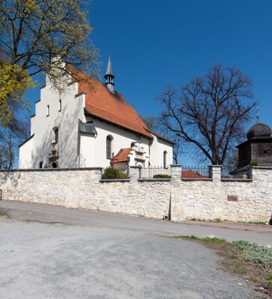 Zdjęcie nr 2: Kościół orientowany, murowany, jednonawowy z węższym prezbiterium zakończonym półkolistą absydą. Przy prezbiterium od północy znajduje się zakrystia, od południa kwadratowa kaplica św. Anny, a przy nawie od południa kruchta. Wnętrze kościoła nakryte jest nowym stropem, natomiast w kaplicy znajduje się sklepienie krzyżowo-żebrowe. Fasada zachodnia ujęta jest na narożnikach skośnymi szkarpami i zwieńczona schodkowym szczytem, podobnie zwieńczona jest kruchta południowa. Portal zachodni kamienny, z belkowaniem wspartym na dwóch liściastych konsolach ponad którymi edikula z płaskorzeźbionym krucyfiksem i klęczącymi postaciami męskimi. Na belkowaniu znajdują się dwa kartusze z herbami: po lewej herb Bończa, a nad nim litery „I” oraz „T”, a na prawo herb Szreniawa i litery „B” i „T”. Portal kruchty południowej jest również kamienny, podobny do zachodniego z inskrypcją: „IN LAVDEM ET GL[ORI]AM DEI O[MN]IP[OTENTIS] HO[NO]RE[M] / B(EATE) M(ARIAE) S(ANCTAE) V(IRGINIS) S(ANCTUS) AEGIDY ET OM(NIUM) SS. FIR. REGNÃTE [TERTIO] SIGISM[UN]DO / REGE POL[ONIAE] Z[?] HEMO[?] EP[ISCOP]O CRAC(OVIENSIS) BERN[AR]DO MACIEIOWSKI / NOVIT[ER] CAR[DINA]LI CRA[COVIENSE] DEI FACTO INTERI[M] PLEBA[N]O R[E]V[EREN]DO SEB(ASTIANO) / NAGRODIO A I SYRADIA PHI[LOSOPHI]AE DOCTORE COLLEG[I]A [MA]IORE / S. T(HEOLOGIAE) PVBLICO PROFES(SORE) PRAEP[OSI]TO S(ANCTA) AN(NAE) CRAC[OVIAE] DECIMARVM / ET FVNDI ECCL(ESIA)E HVIVS P[OST] IVRIS STREPITV(M) RESTITV / TORE ANNO OCTAVO PLEBANAT[U]S SVI. TEMPLVM HO(C) / [ dwa wiersze skute] DE' / NOWO AEDIFICATVM. ET. CONSTRVCTVM. ADIVTORIO / QVORVNDÃ ANNO D[OMINI] MDCIIII MENSE SEPTEMB[RE]”. Od południa świątyni umieszczone są trzy otwory okienne w kształcie stojących prostokątów, zamkniętych łukiem półkolistym, a w prezbiterium dwa małe okrągłe okna. Kościół nakryty jest dwoma dwuspadowymi dachami, nad prezbiterium nieco niższym, nad nawą zwieńczonym wąską i wysoką sygnaturką na dzwon. Wewnątrz świątyni na skrzyżowaniu nawy i prezbiterium umocowana jest drewniana belka tęczowa z ustawionym na niej krucyfiksem i figurami Matki Boskiej i św. Jana Ewangelisty. Chór zachodni drewniany, na planie prostokąta, pośrodku półkoliście zamknięty, wsparty na sześciu filarach, od północnego zachodu z obudowaną boazerią klatką schodową. 