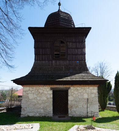 Zdjęcie nr 105: Kościół orientowany, murowany, jednonawowy z węższym prezbiterium zakończonym półkolistą absydą. Przy prezbiterium od północy znajduje się zakrystia, od południa kwadratowa kaplica św. Anny, a przy nawie od południa kruchta. Wnętrze kościoła nakryte jest nowym stropem, natomiast w kaplicy znajduje się sklepienie krzyżowo-żebrowe. Fasada zachodnia ujęta jest na narożnikach skośnymi szkarpami i zwieńczona schodkowym szczytem, podobnie zwieńczona jest kruchta południowa. Portal zachodni kamienny, z belkowaniem wspartym na dwóch liściastych konsolach ponad którymi edikula z płaskorzeźbionym krucyfiksem i klęczącymi postaciami męskimi. Na belkowaniu znajdują się dwa kartusze z herbami: po lewej herb Bończa, a nad nim litery „I” oraz „T”, a na prawo herb Szreniawa i litery „B” i „T”. Portal kruchty południowej jest również kamienny, podobny do zachodniego z inskrypcją: „IN LAVDEM ET GL[ORI]AM DEI O[MN]IP[OTENTIS] HO[NO]RE[M] / B(EATE) M(ARIAE) S(ANCTAE) V(IRGINIS) S(ANCTUS) AEGIDY ET OM(NIUM) SS. FIR. REGNÃTE [TERTIO] SIGISM[UN]DO / REGE POL[ONIAE] Z[?] HEMO[?] EP[ISCOP]O CRAC(OVIENSIS) BERN[AR]DO MACIEIOWSKI / NOVIT[ER] CAR[DINA]LI CRA[COVIENSE] DEI FACTO INTERI[M] PLEBA[N]O R[E]V[EREN]DO SEB(ASTIANO) / NAGRODIO A I SYRADIA PHI[LOSOPHI]AE DOCTORE COLLEG[I]A [MA]IORE / S. T(HEOLOGIAE) PVBLICO PROFES(SORE) PRAEP[OSI]TO S(ANCTA) AN(NAE) CRAC[OVIAE] DECIMARVM / ET FVNDI ECCL(ESIA)E HVIVS P[OST] IVRIS STREPITV(M) RESTITV / TORE ANNO OCTAVO PLEBANAT[U]S SVI. TEMPLVM HO(C) / [ dwa wiersze skute] DE' / NOWO AEDIFICATVM. ET. CONSTRVCTVM. ADIVTORIO / QVORVNDÃ ANNO D[OMINI] MDCIIII MENSE SEPTEMB[RE]”. Od południa świątyni umieszczone są trzy otwory okienne w kształcie stojących prostokątów, zamkniętych łukiem półkolistym, a w prezbiterium dwa małe okrągłe okna. Kościół nakryty jest dwoma dwuspadowymi dachami, nad prezbiterium nieco niższym, nad nawą zwieńczonym wąską i wysoką sygnaturką na dzwon. Wewnątrz świątyni na skrzyżowaniu nawy i prezbiterium umocowana jest drewniana belka tęczowa z ustawionym na niej krucyfiksem i figurami Matki Boskiej i św. Jana Ewangelisty. Chór zachodni drewniany, na planie prostokąta, pośrodku półkoliście zamknięty, wsparty na sześciu filarach, od północnego zachodu z obudowaną boazerią klatką schodową. 