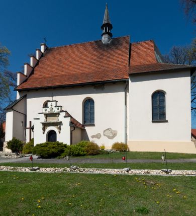 Zdjęcie nr 52: Kościół orientowany, murowany, jednonawowy z węższym prezbiterium zakończonym półkolistą absydą. Przy prezbiterium od północy znajduje się zakrystia, od południa kwadratowa kaplica św. Anny, a przy nawie od południa kruchta. Wnętrze kościoła nakryte jest nowym stropem, natomiast w kaplicy znajduje się sklepienie krzyżowo-żebrowe. Fasada zachodnia ujęta jest na narożnikach skośnymi szkarpami i zwieńczona schodkowym szczytem, podobnie zwieńczona jest kruchta południowa. Portal zachodni kamienny, z belkowaniem wspartym na dwóch liściastych konsolach ponad którymi edikula z płaskorzeźbionym krucyfiksem i klęczącymi postaciami męskimi. Na belkowaniu znajdują się dwa kartusze z herbami: po lewej herb Bończa, a nad nim litery „I” oraz „T”, a na prawo herb Szreniawa i litery „B” i „T”. Portal kruchty południowej jest również kamienny, podobny do zachodniego z inskrypcją: „IN LAVDEM ET GL[ORI]AM DEI O[MN]IP[OTENTIS] HO[NO]RE[M] / B(EATE) M(ARIAE) S(ANCTAE) V(IRGINIS) S(ANCTUS) AEGIDY ET OM(NIUM) SS. FIR. REGNÃTE [TERTIO] SIGISM[UN]DO / REGE POL[ONIAE] Z[?] HEMO[?] EP[ISCOP]O CRAC(OVIENSIS) BERN[AR]DO MACIEIOWSKI / NOVIT[ER] CAR[DINA]LI CRA[COVIENSE] DEI FACTO INTERI[M] PLEBA[N]O R[E]V[EREN]DO SEB(ASTIANO) / NAGRODIO A I SYRADIA PHI[LOSOPHI]AE DOCTORE COLLEG[I]A [MA]IORE / S. T(HEOLOGIAE) PVBLICO PROFES(SORE) PRAEP[OSI]TO S(ANCTA) AN(NAE) CRAC[OVIAE] DECIMARVM / ET FVNDI ECCL(ESIA)E HVIVS P[OST] IVRIS STREPITV(M) RESTITV / TORE ANNO OCTAVO PLEBANAT[U]S SVI. TEMPLVM HO(C) / [ dwa wiersze skute] DE' / NOWO AEDIFICATVM. ET. CONSTRVCTVM. ADIVTORIO / QVORVNDÃ ANNO D[OMINI] MDCIIII MENSE SEPTEMB[RE]”. Od południa świątyni umieszczone są trzy otwory okienne w kształcie stojących prostokątów, zamkniętych łukiem półkolistym, a w prezbiterium dwa małe okrągłe okna. Kościół nakryty jest dwoma dwuspadowymi dachami, nad prezbiterium nieco niższym, nad nawą zwieńczonym wąską i wysoką sygnaturką na dzwon. Wewnątrz świątyni na skrzyżowaniu nawy i prezbiterium umocowana jest drewniana belka tęczowa z ustawionym na niej krucyfiksem i figurami Matki Boskiej i św. Jana Ewangelisty. Chór zachodni drewniany, na planie prostokąta, pośrodku półkoliście zamknięty, wsparty na sześciu filarach, od północnego zachodu z obudowaną boazerią klatką schodową. 